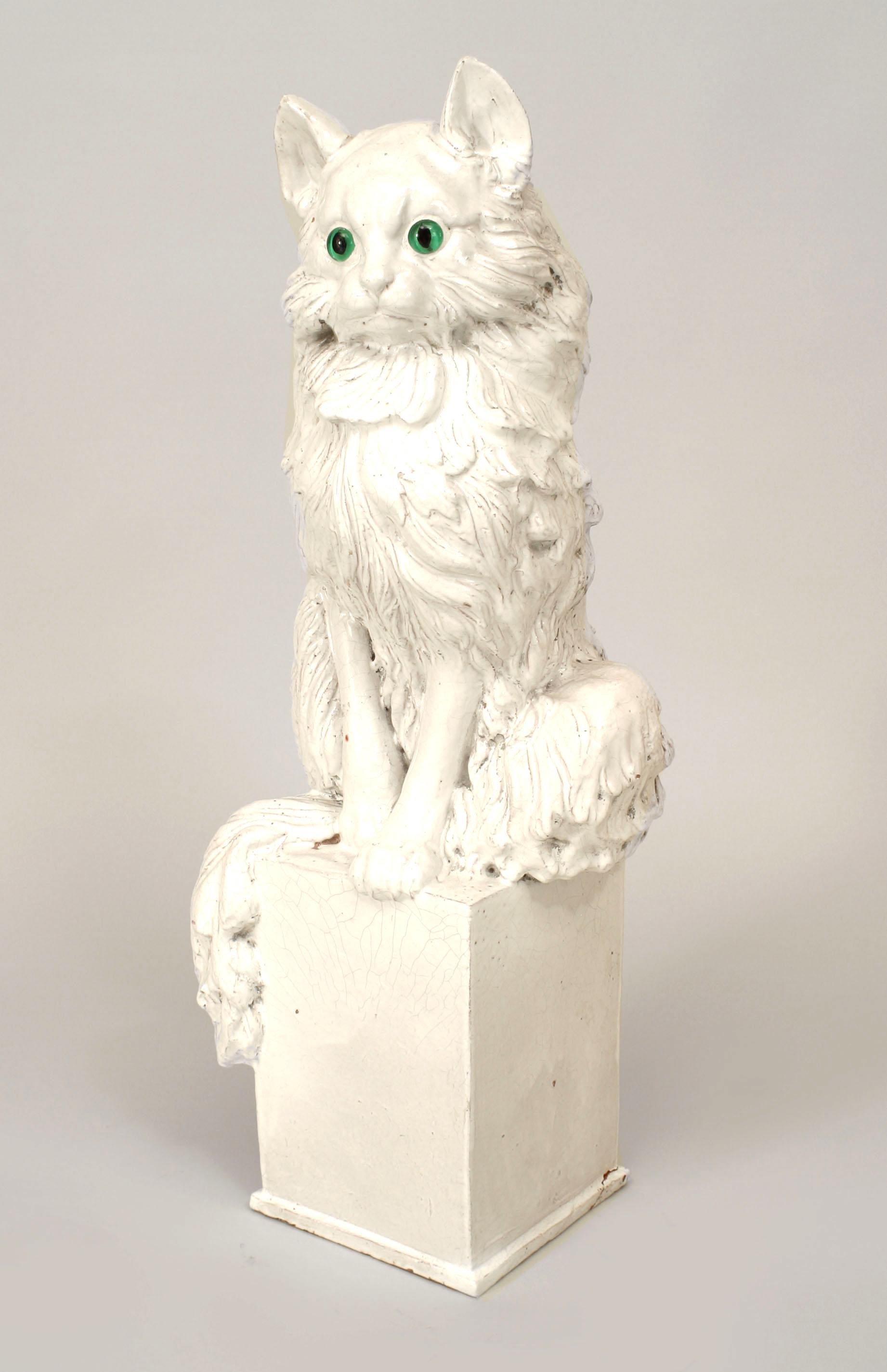 Italian 1950s white ceramic figure of a life size seated cat with green eyes perched on a square pedestal base
