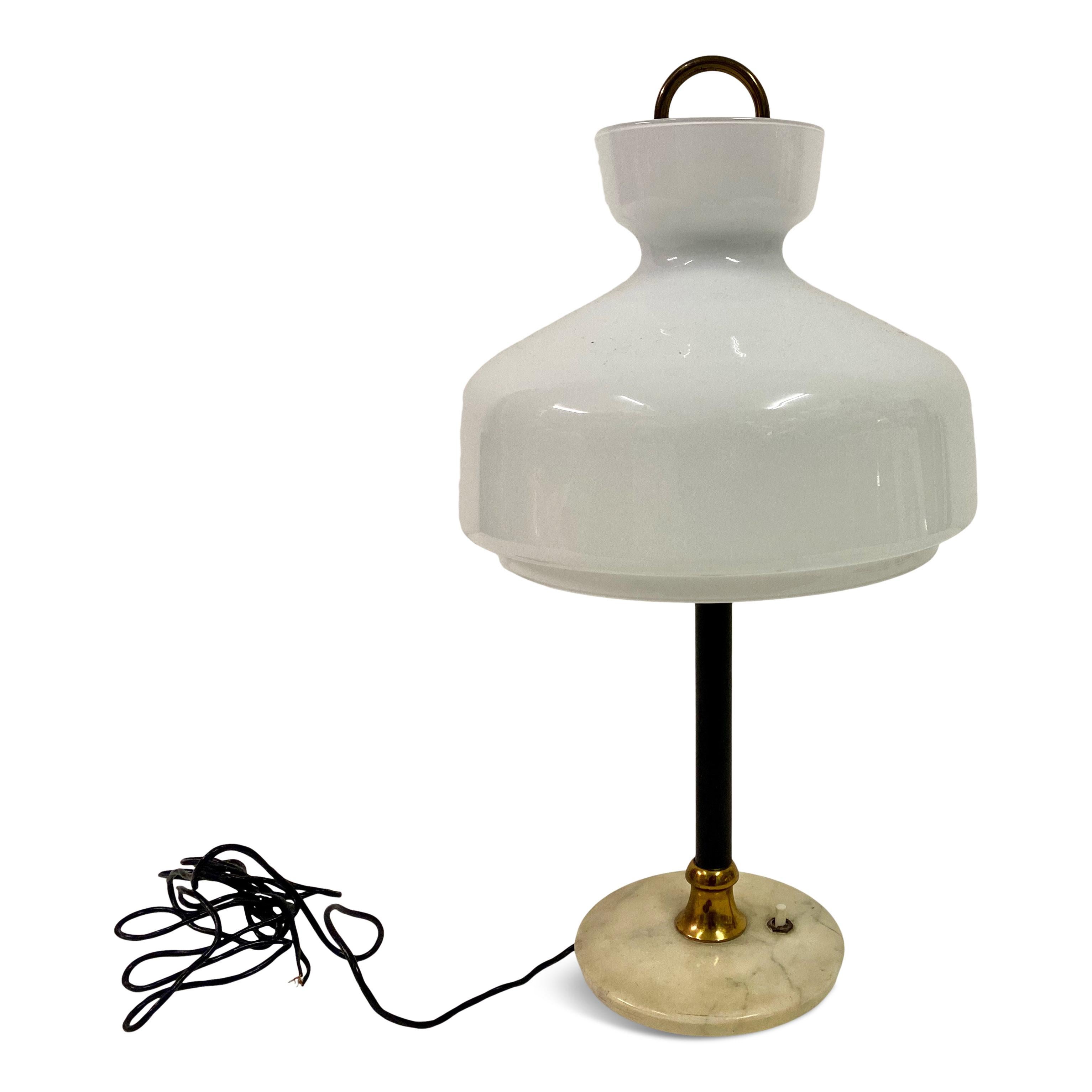 Table lamp

White opaline glass shade

Black metal stem

Marble base

Brass ring

Italy 1950s.