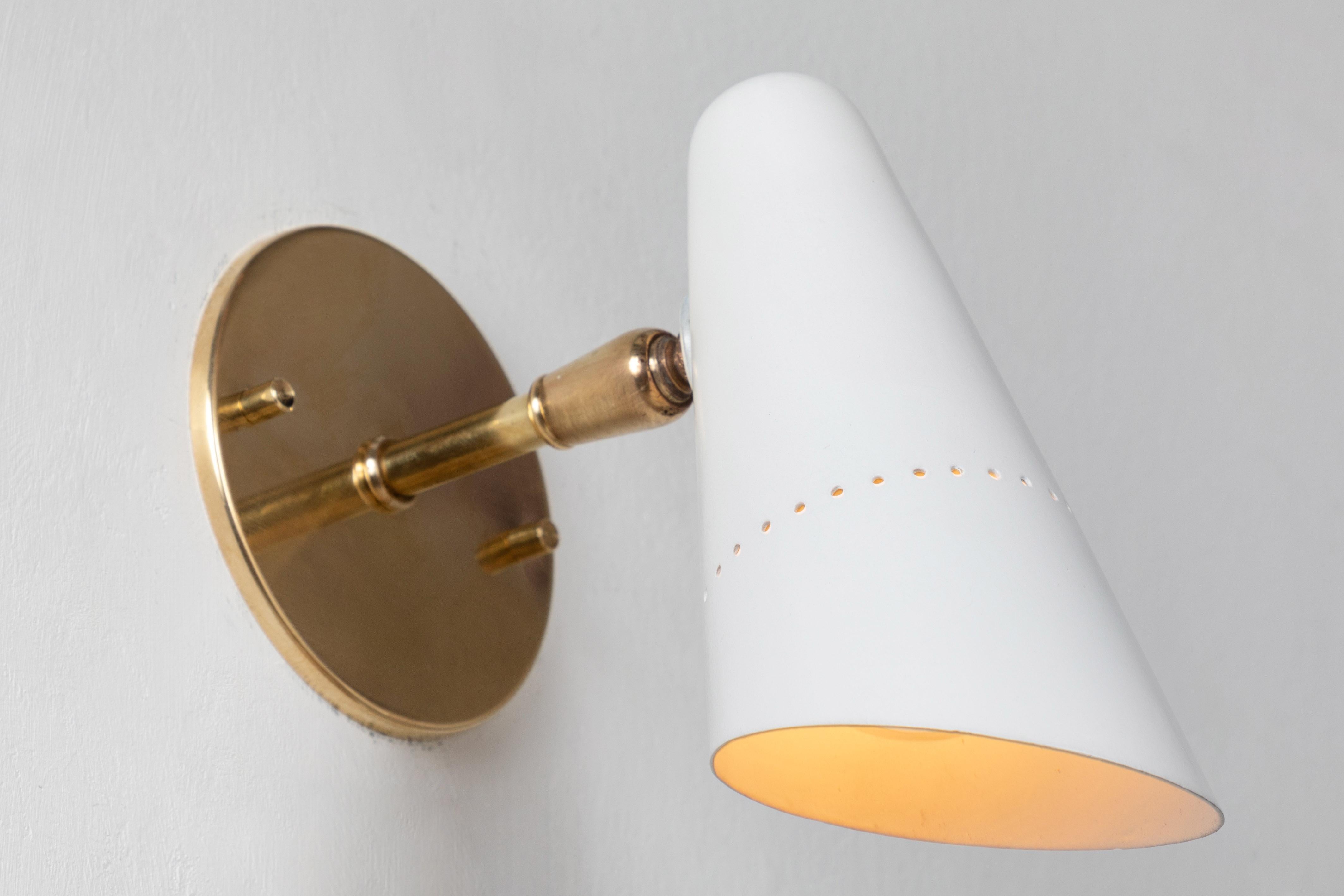 1950s Italian white articulating sconces attributed to Gino Sarfatti. Executed in brass and white painted aluminum. Sconces pivot up/down and left/right on a ball joint. Custom period styled brass backplates with brass hardware for hardwiring over a