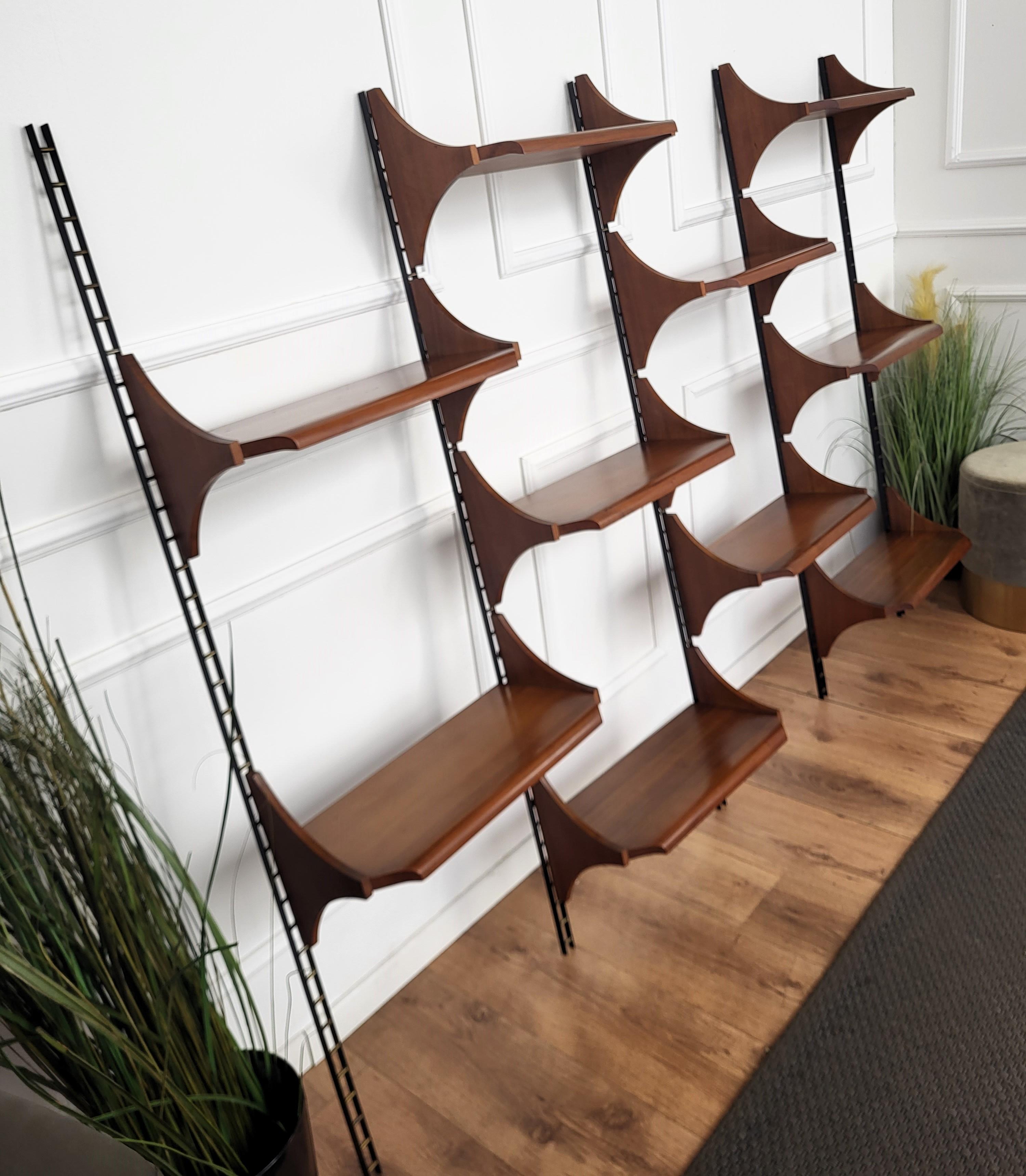 A very stylish 1950s Italian shelving system. This robust and solid shelving system or bookcase, consists of ten adjustable teak shelves that rest on metal and brass brackets. The shelves are adjustable due to the fixing holes that run the full