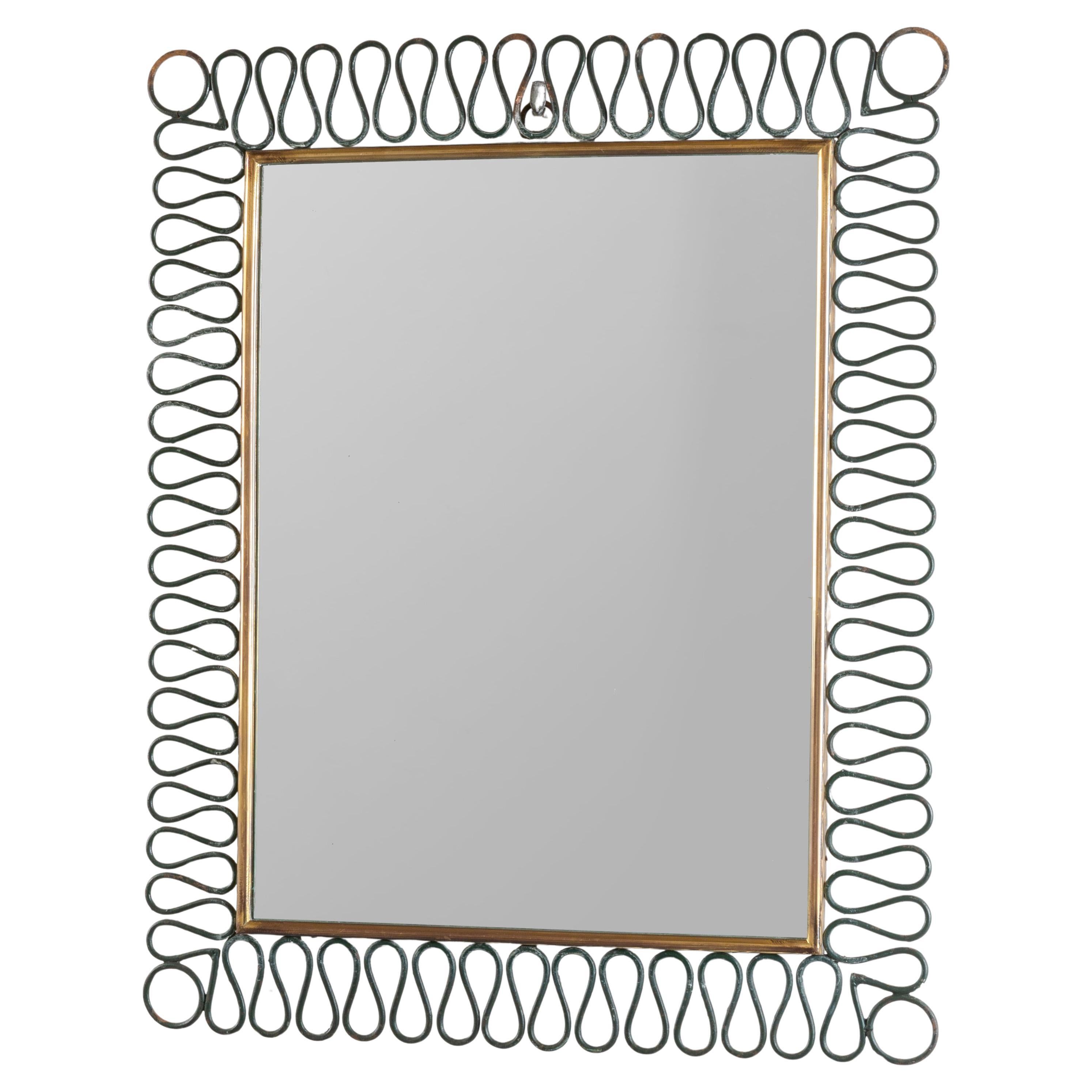 A 1950s Italian Wall Mirror with a decorative scalloped steel frame.

The metalwork has a wonderful patina. The original green paintwork is rubbed in places to blackened steel and the brass frame has a lovely antique finish. The mirror plate is