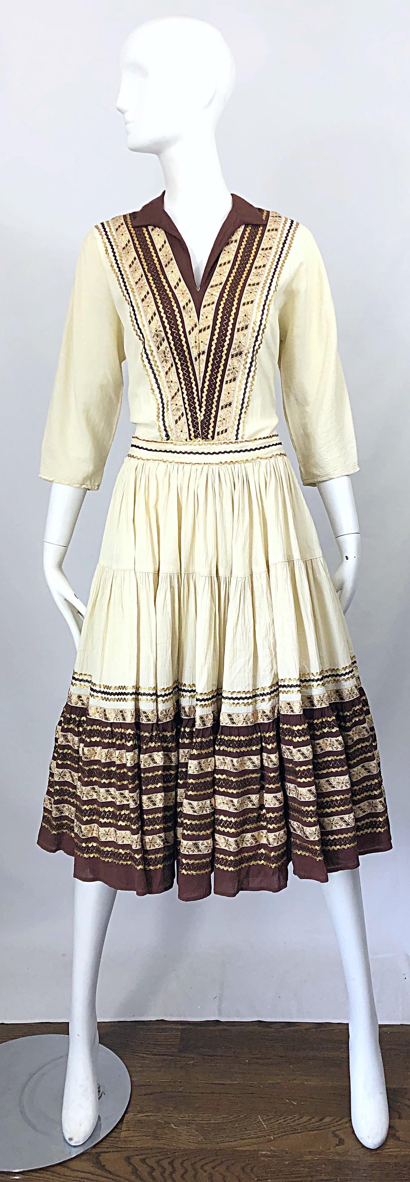 Beautiful 1950s lightweight silk ivory, brown and gold embroidered tunic and skirt ensemble / patio dress ! 
Tunic top features brown and gold ric rac and gold embroidered flowers throughout the front. Blouse simply slips over the head with hidden