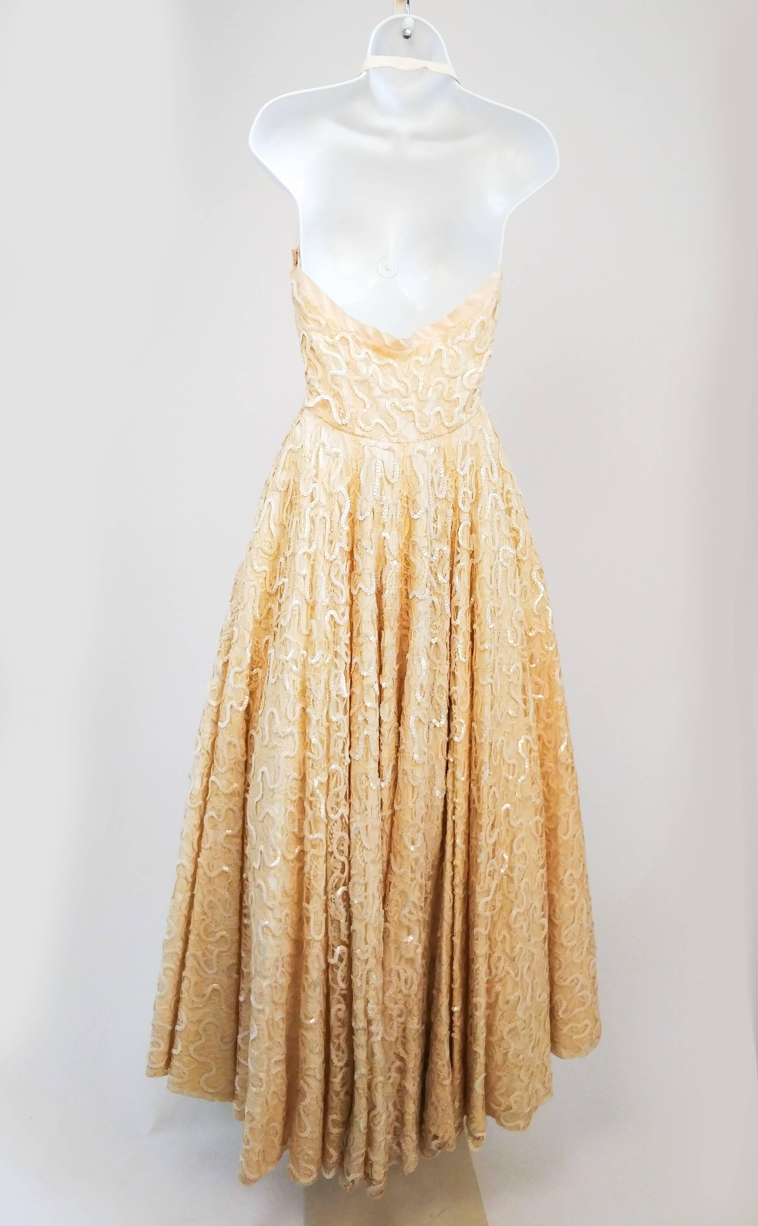 1950s Ivory Sequin Halterneck Gown. Gathered sweetheart neckline, nips in at natural waist. Full length flared skirt serves ultimate glamour, the entire dress is covered in sequins and very luxurious and heavy. 