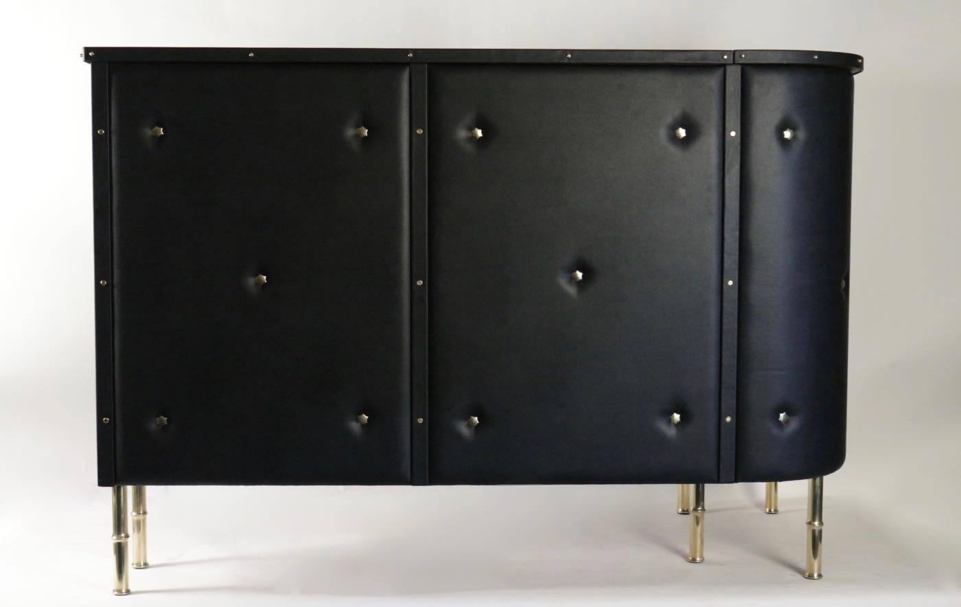1950s Jacques Adnet bar ? L-shaped, covered in padded black leatherette decorated with brass stars, standing on six brass bamboo style legs.

Origin France, 1950

Dimensions : 
H 45 ¾ in 
L 59 ½ in 
D 32 in.
 
