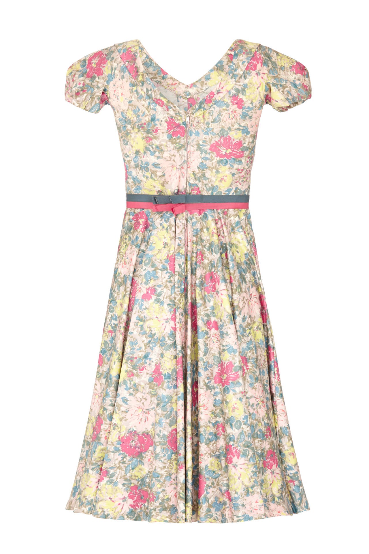This enchanting 1950s or early 1960s floral print polished cotton dress from American label Jane Derby when Oscar de la Renta was the head designer showcases some exquisite tailoring complete with its original grosgrain ribbon belt. The gently
