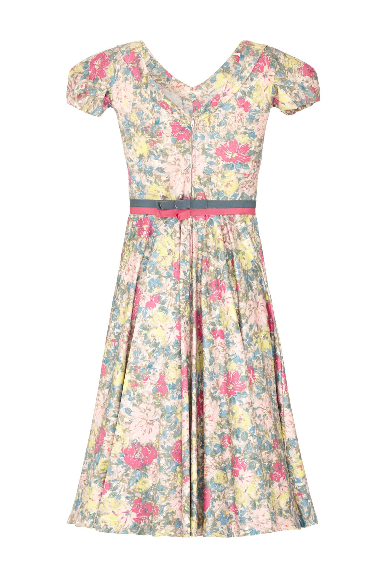 This enchanting 1950s or early 1960s floral print polished cotton dress from American label Jane Derby when Oscar de la Renta was the head designer showcases some exquisite tailoring complete with its original grosgrain ribbon belt. The gently