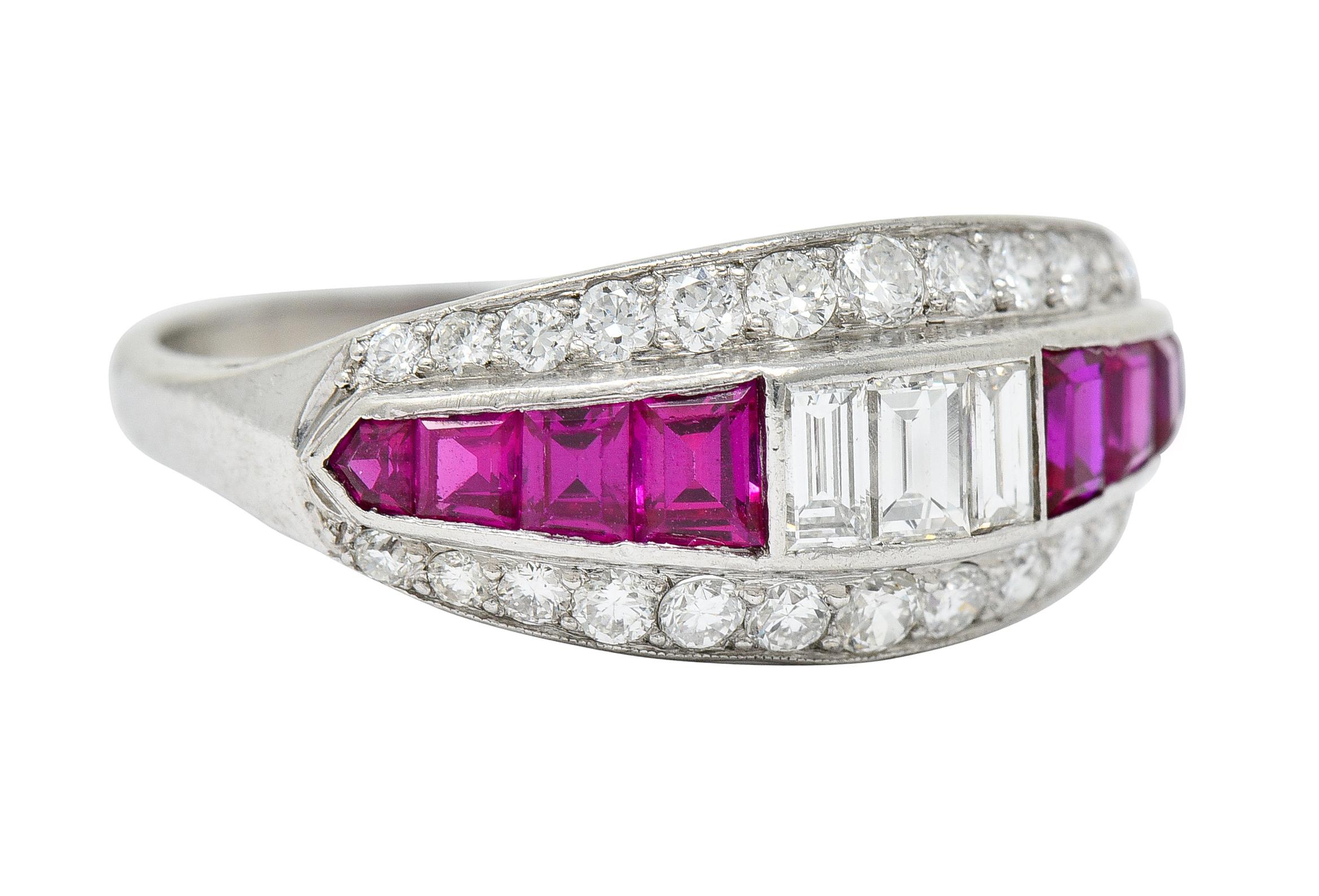 Band ring centers a row of channel set baguette cut diamonds flanked by calibré cut rubies

Flanked North and South by two rows of round brilliant cut diamonds - graduating in size

Rubies very well matched purplish red color while weighing