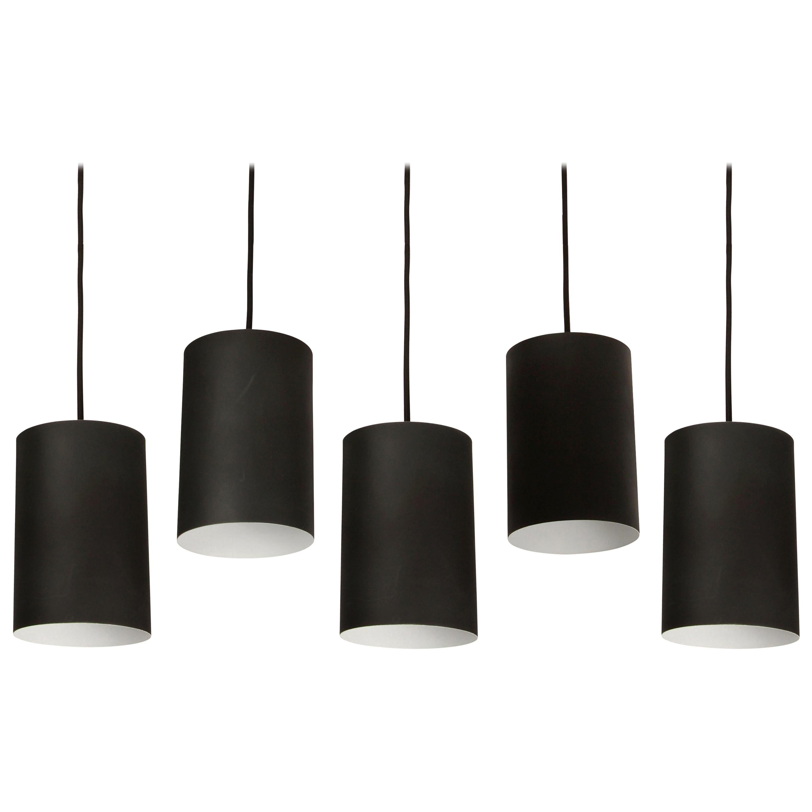 1950s Jo Hammerborg Pendant for Louis Poulsen. Executed in black painted cylindrical metal with custom patinated brass canopy and thick black cloth cord, Denmark, circa 1950s.

Price is per item. Three lamps available.

Not UL listed, but available