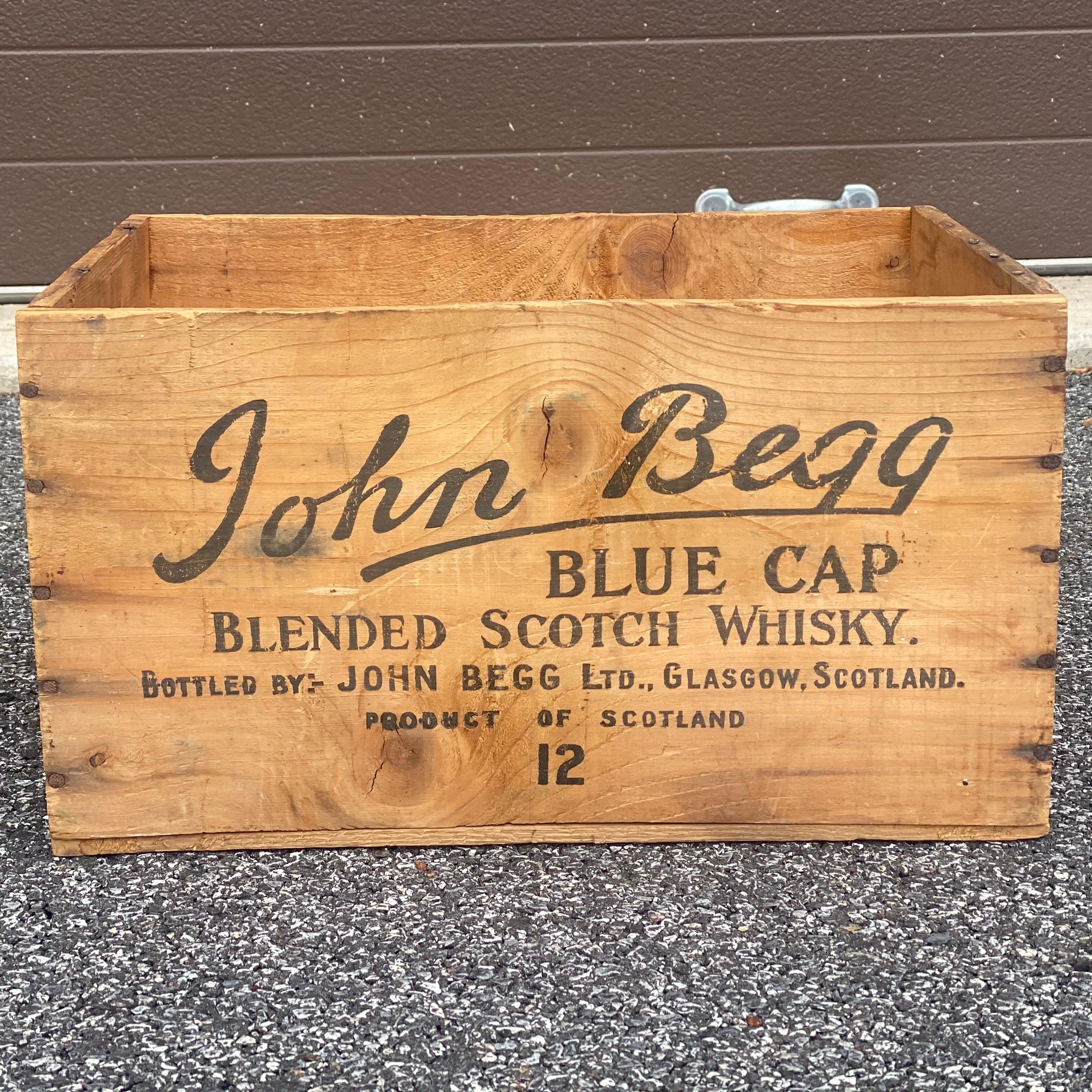 Vintage John Begg Blue Cap Blended Scotch Whiskey wooden crate with lettering on four sides
Circa 1950s.
Interior dimensions roughly 
11.75”x 15.375” x 8.75”h