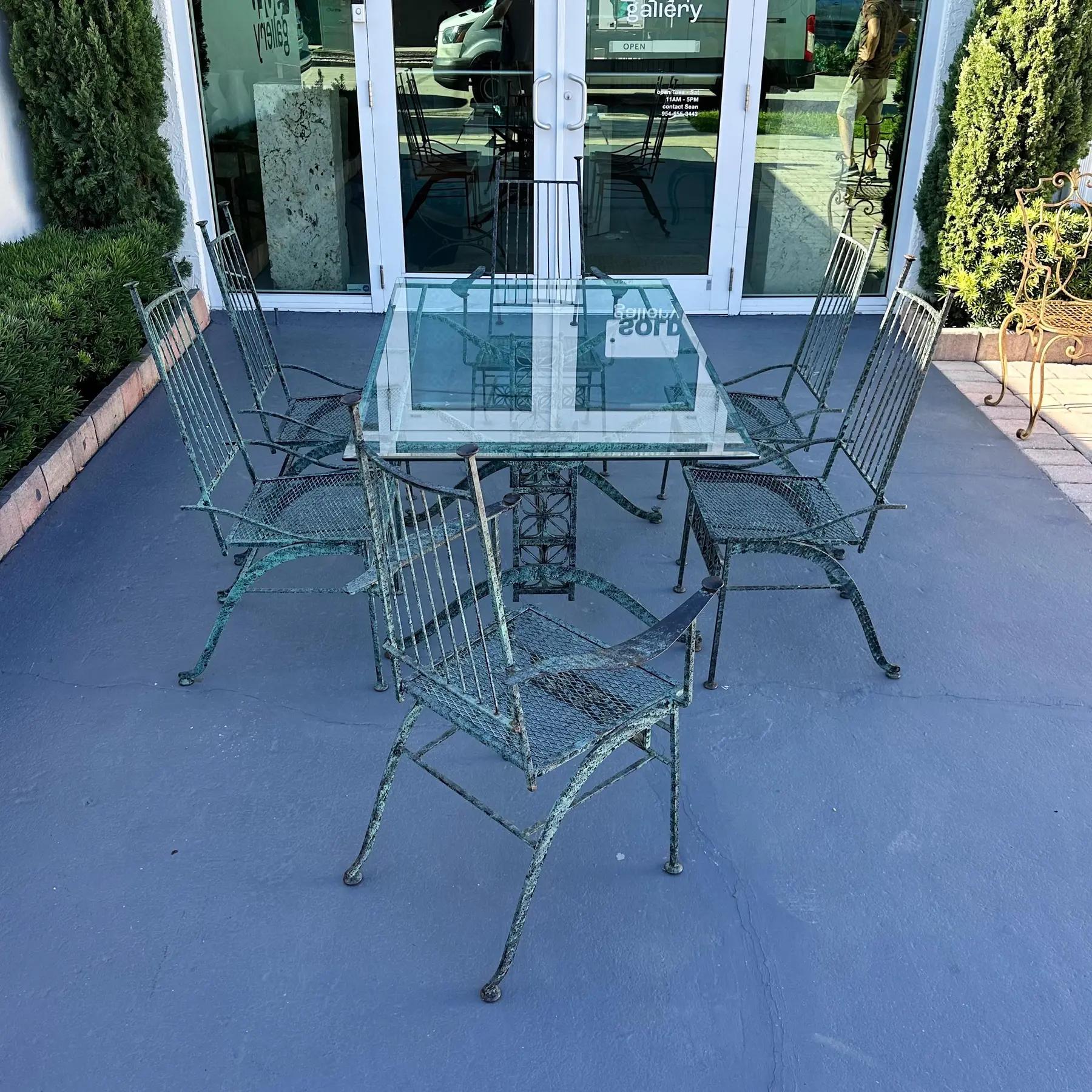 John Salterini 'El Prado' Collection wrought iron dining table with a vintage applied verdigris finish. Finish is in good vintage condition with slight wear from age and use. Feet are copper or brass. Two armchairs and four side chairs. As is with