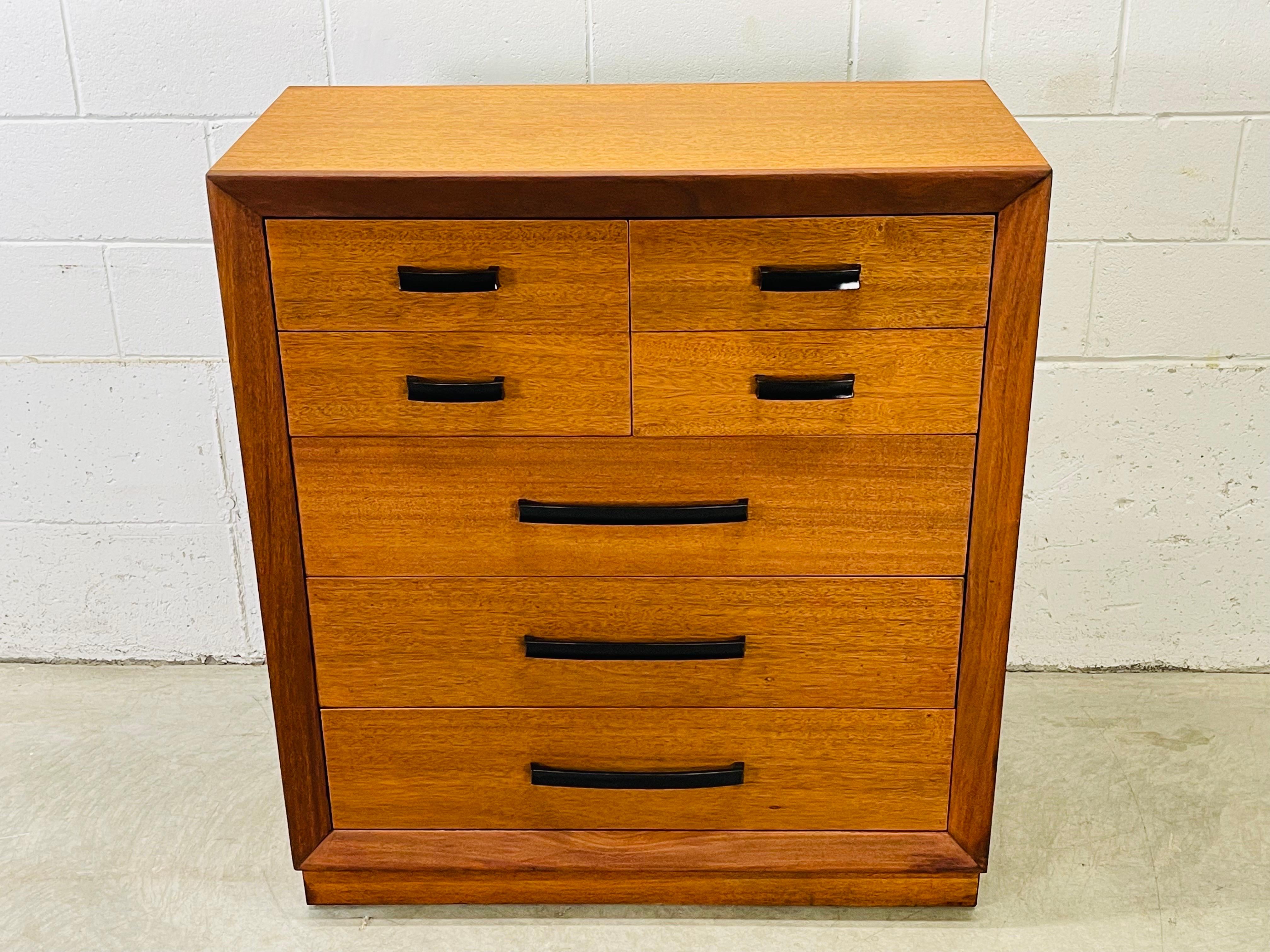 Vintage 1950s John Stuart teak wood seven drawer tall deesser with black metal pulls. The dresser drawers measure from 4”-6”H for lots of storage. The drawer interiors are solid oak wood. Newly refinished condition. Marked in the drawer.