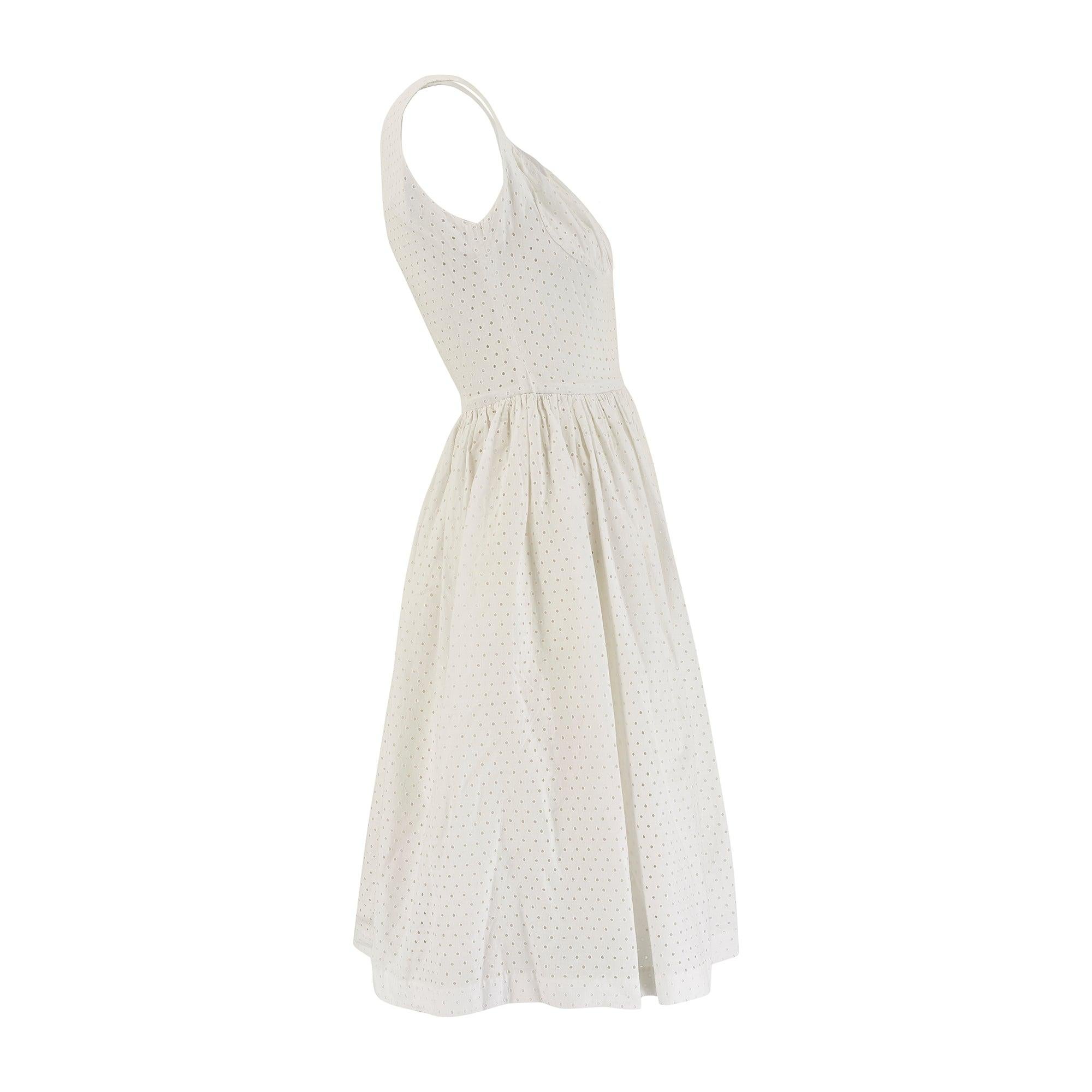 Este bonito vestido de verano de algodón de los años 50 fue diseñado por Josselyne de París. Hay algo muy contemporáneo en el diseño: el algodón blanco impoluto con detalles de ojales, el corpiño fruncido, la falda de largo midi. La parte superior