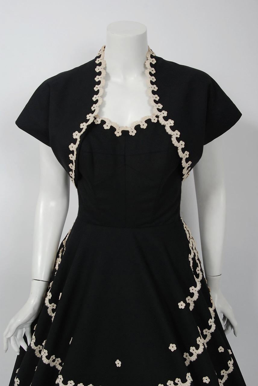 Elegant 1950's black cotton-piqué dress set from the iconic California couturier Juli Lynne Charlot. Juli Lynne Charlot was an actress turned designer. In 1947, she designed a felt circle-skirt which she decorated with appliquéd Christmas trees.