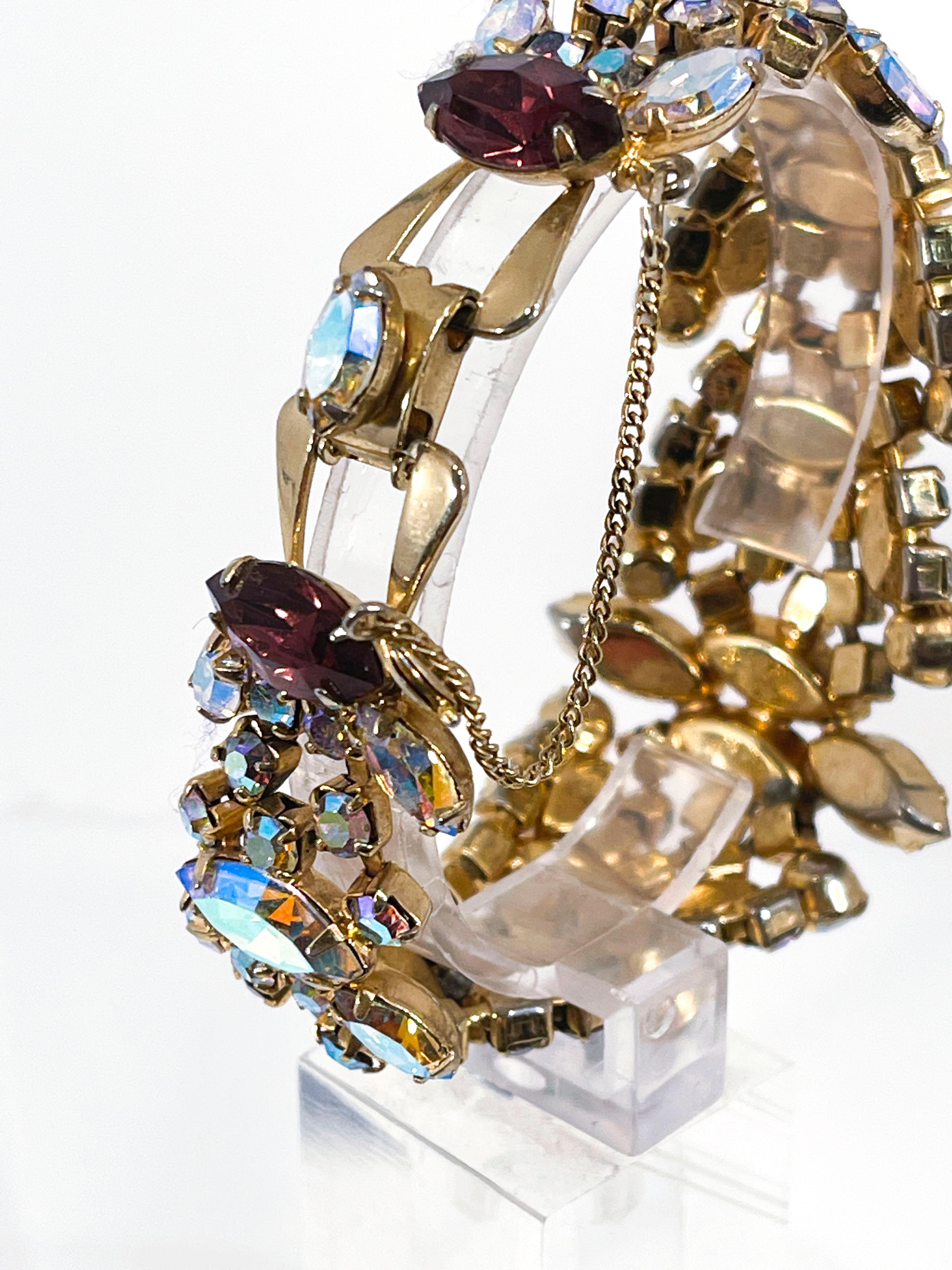 1950's Juliana Aurora Borealis iridescent rhinestone bracelet with purple accents. Gold toned metal security chain attached. Most of Juliana's pieces from this time period were unmarked however, this piece is emblematic of her high design of fashion