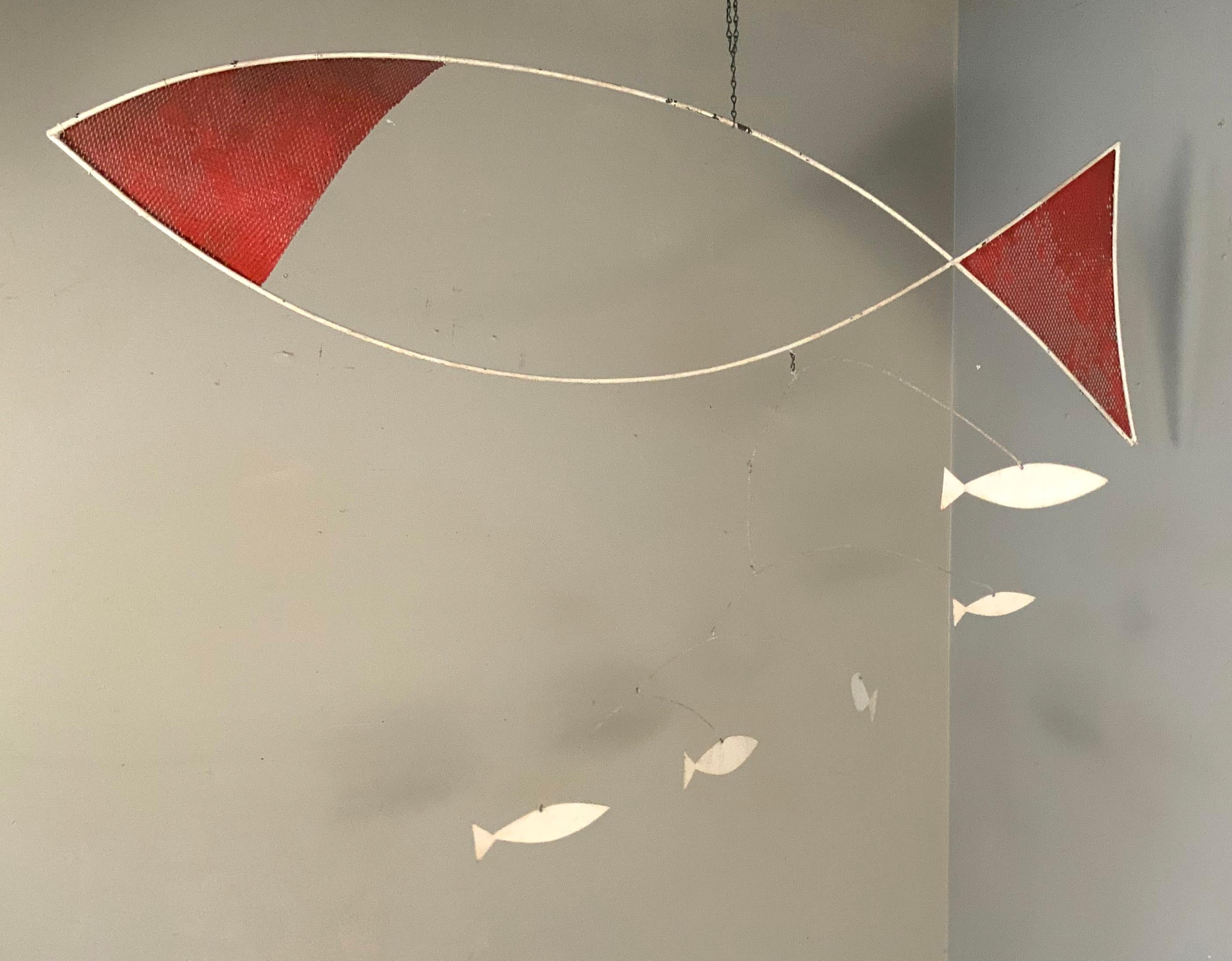 A beautiful and engaging 1950s hanging mobile, with handmade iron frame of a large swimming fish, with five smaller hanging fish, in varying levels and places, hanging from the large fish, each of which moves independently.

A very charming