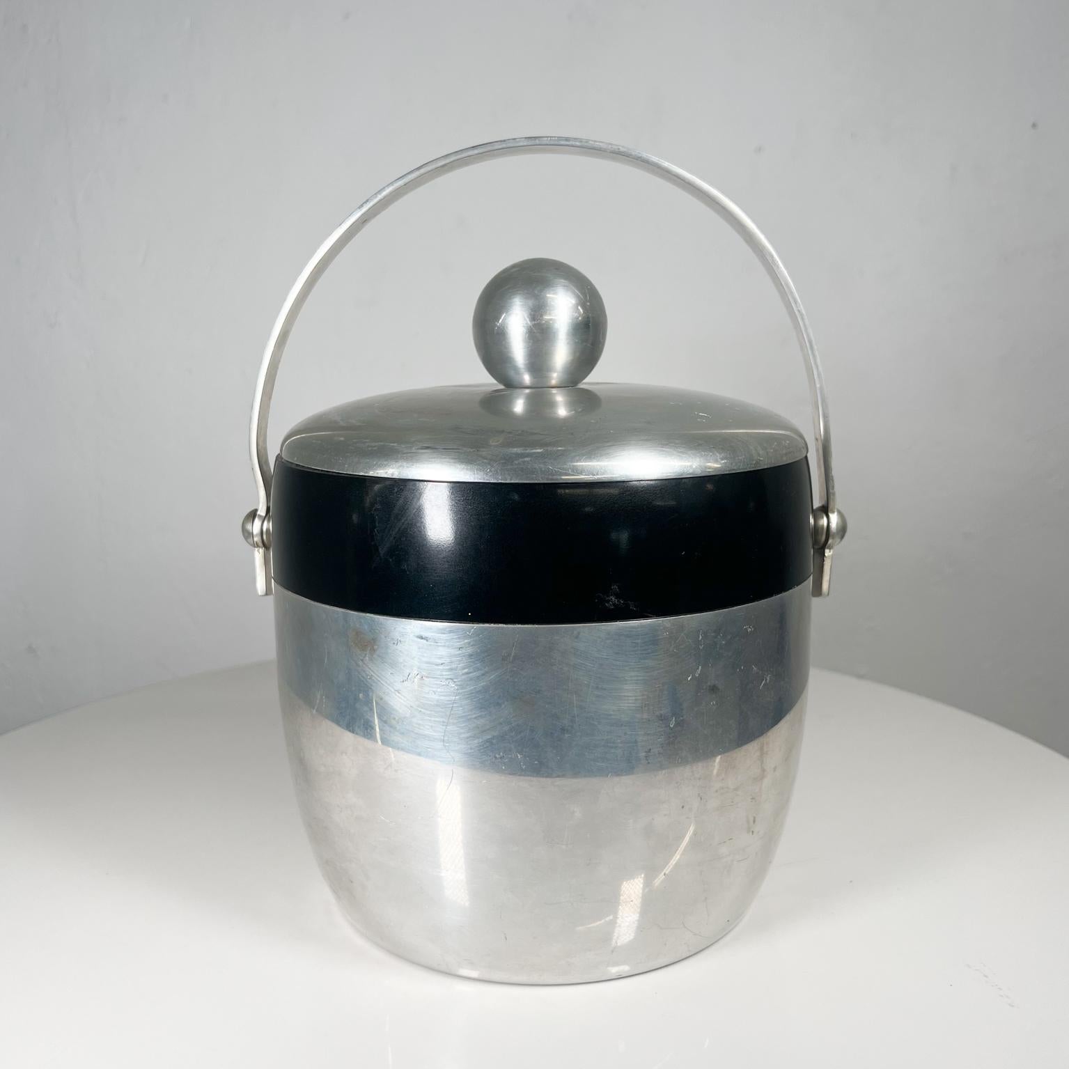 1950s Kromex ice bucket atomic silver and black
Enduringly beautiful in Aluminum
Measures: 9.5 tall 11.5 tall with handle x 7.75 diameter
Preowned vintage condition.
Refer to images listed please.