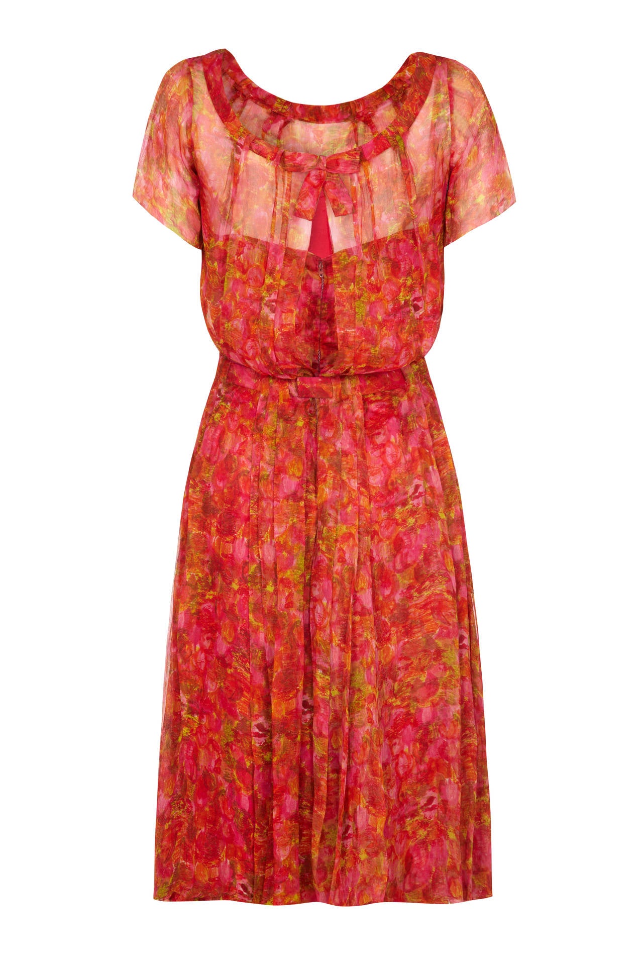This absolutely exquisite 1950s dress in soft crimson, pink, green and orange printed silk chiffon is from English label Lachasse and is of excellent quality with superb couture construction. Although we can not be certain of the designer it is most