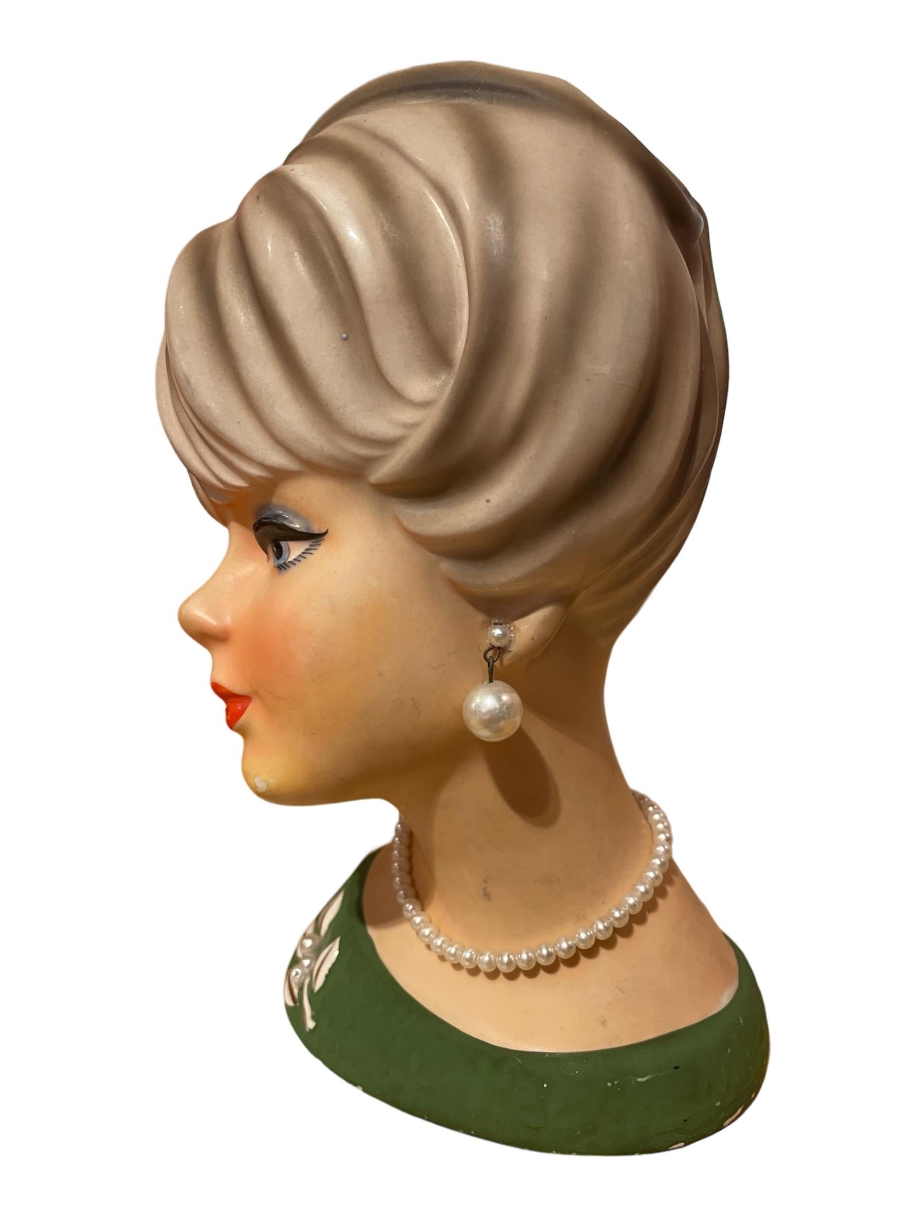 1950s Vintage Lady Head Napcoware Vase with Pearl Earrings and Necklace

Adorable 1950s lady head vase with dangling pearl earrings and pearl necklace. She is wearing a green blouse with pearl accent brooch.

Small paint chip on chin and slight