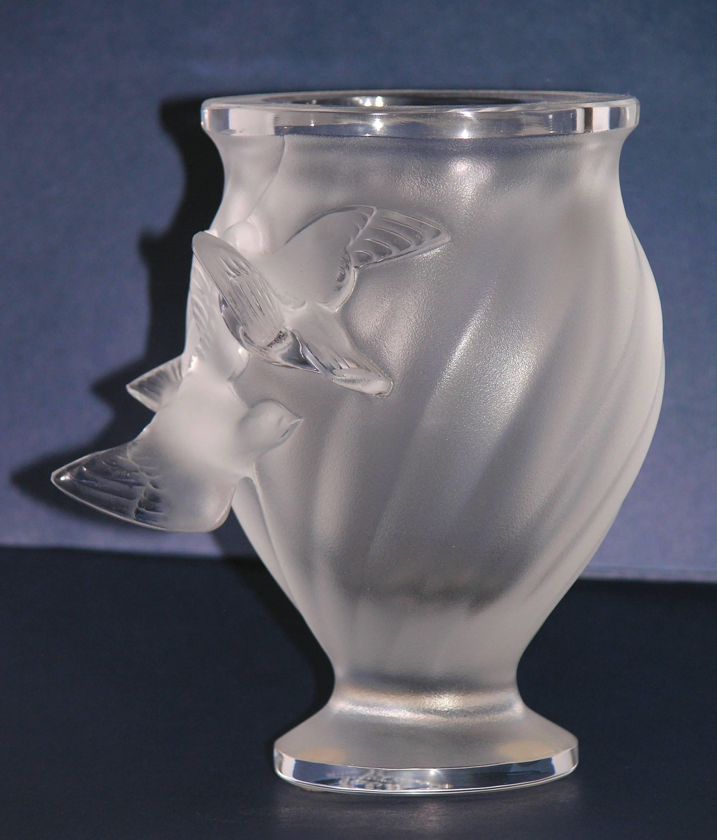 An elegant frosted crystal vase of oval shape by Lalique in the Rosine pattern designed by Marie Lalique in 1950. This vintage piece from the 1950s presents a molded swirl design on the body, decorated in relief with two birds in flight, raised on a