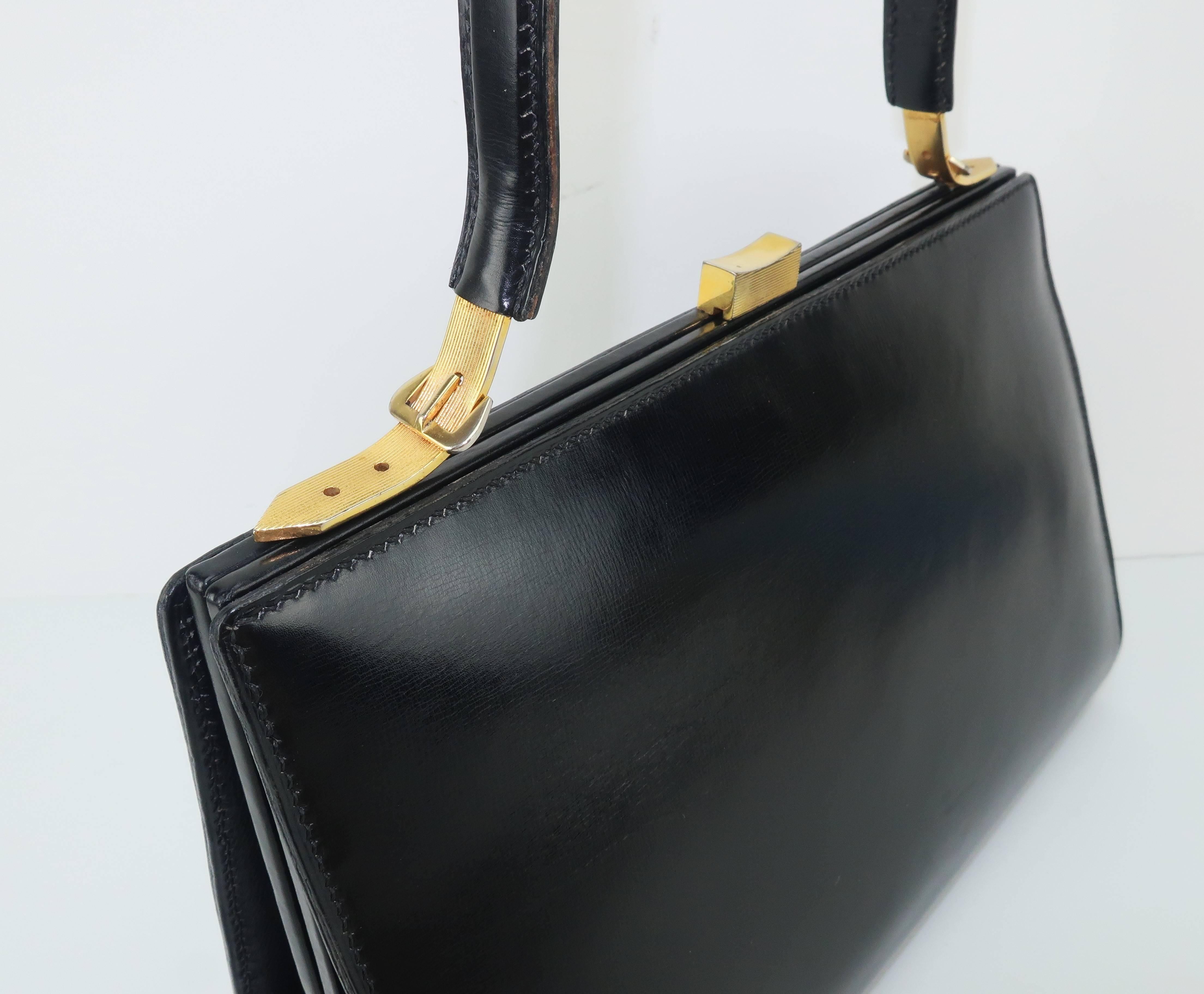 Lancel has been producing handbags in Paris, France since the late 1800’s ... always with an eye for the needs and desires of an independent and modern woman.  This classic 1950’s black leather handbag has a unique profile with a right angle corner