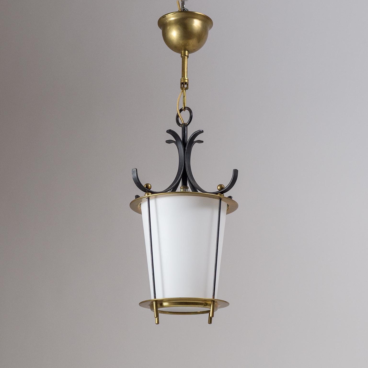 Charming midcentury lantern with a satin glass diffuser, brass hardware as well as black lacquered elements. Very nice original condition with a light patina on the brass and some minor loss of original paint. One original E14 socket with new wiring.