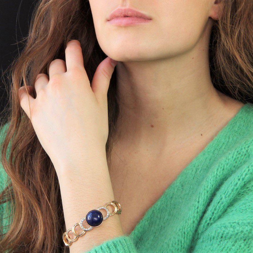 Bracelet in 18 karat yellow gold.
Magnificent retro gold bracelet, it is made of gold semicircle motifs articulated between them retaining on top a lapis lazuli cabochon closed set . On either side of the central gem, 2 semi-circles are set with