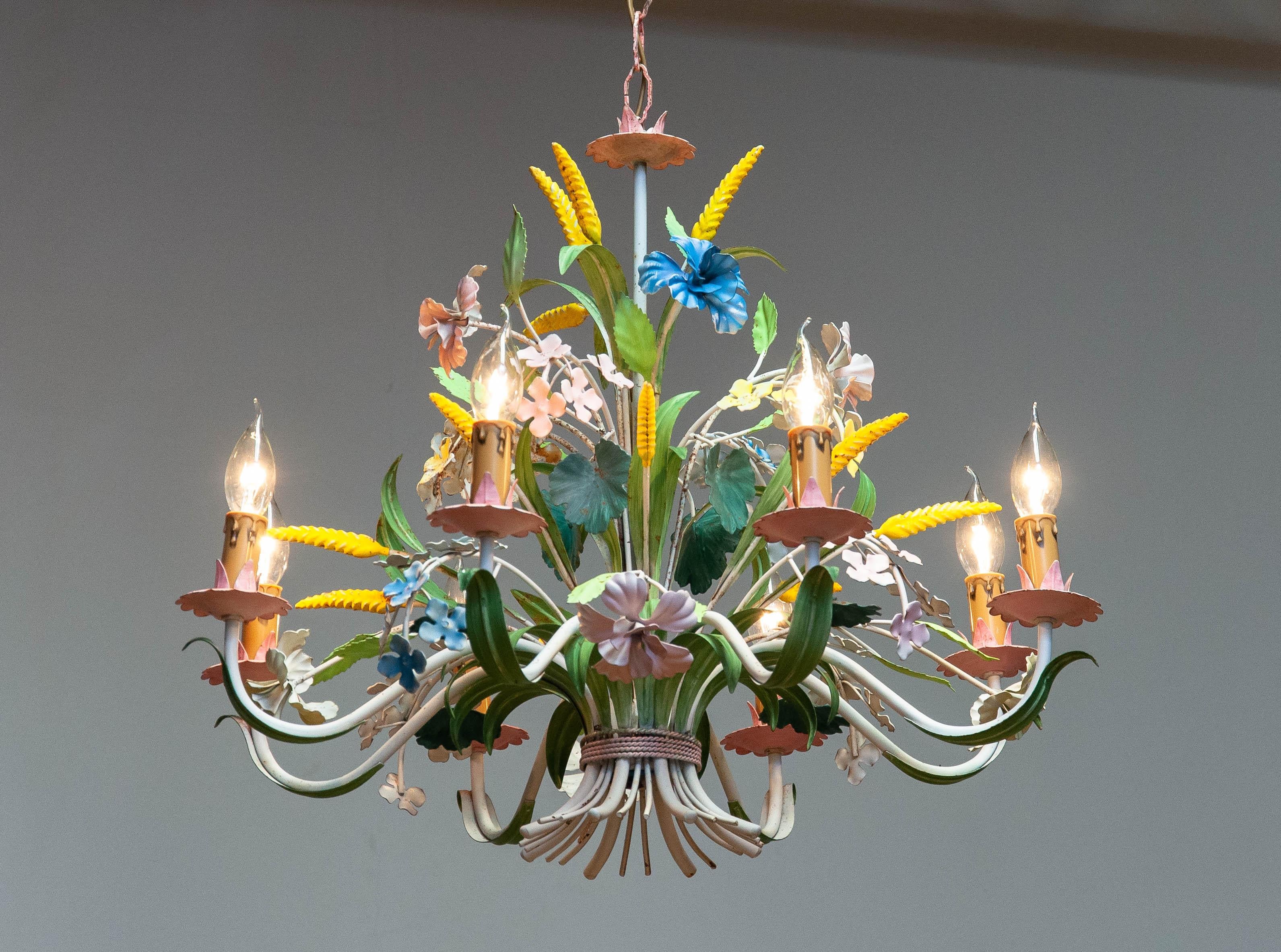 Absolutely beautiful large tole painted chandelier Made in the 1950s in Italy. Beautiful bright colors ar used to give this chandelier her fresh appearance and character.
Wiring has been replaced in a later period as well as the eight screw