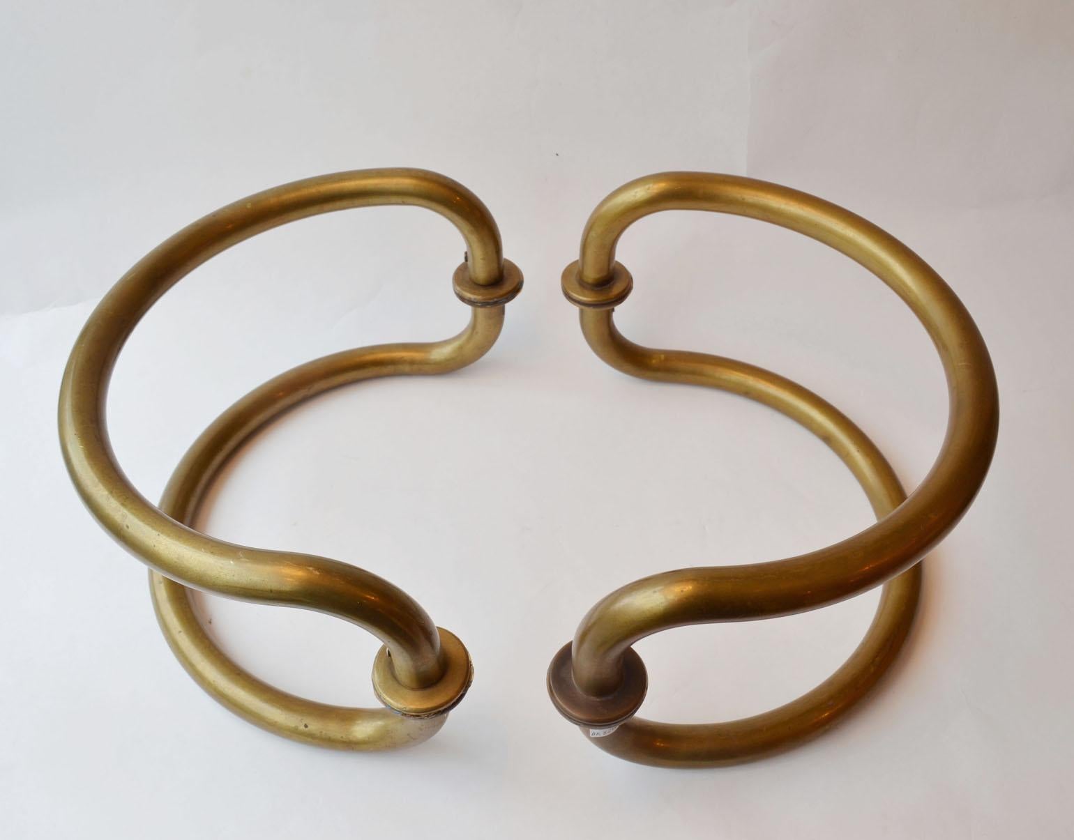 Large pair of Mid Century Modern curvaceous large tubular brass door handles originally made for glass double doors on both sides.
These door handles were designed in the 1930-1950's for front doors. They are multipurpose and can be used in or