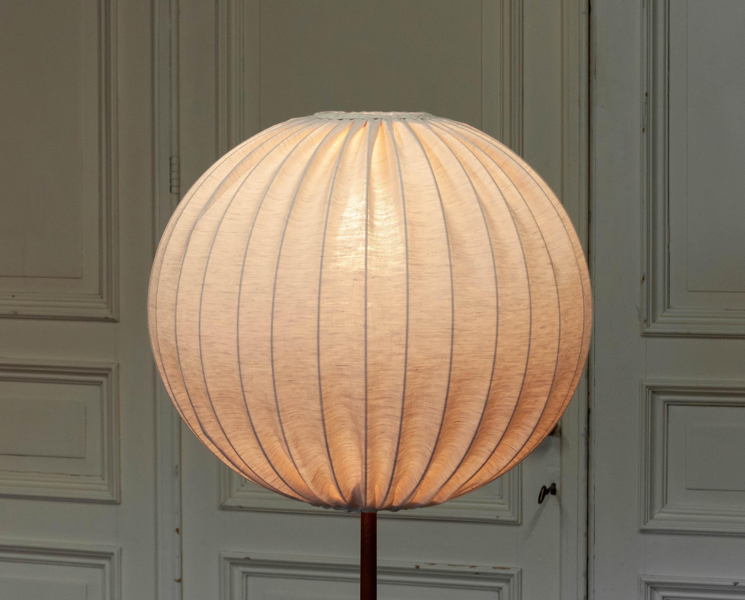 Thiele Holland is delighted to offer a luxurious beautiful 1950s floor lamp designed by Uno & Östen Kristiansson and produced by Luxus, Vittsjö, Sweden. The lamp features a refined teak wooden tripod stand that perfectly balances the large spherical