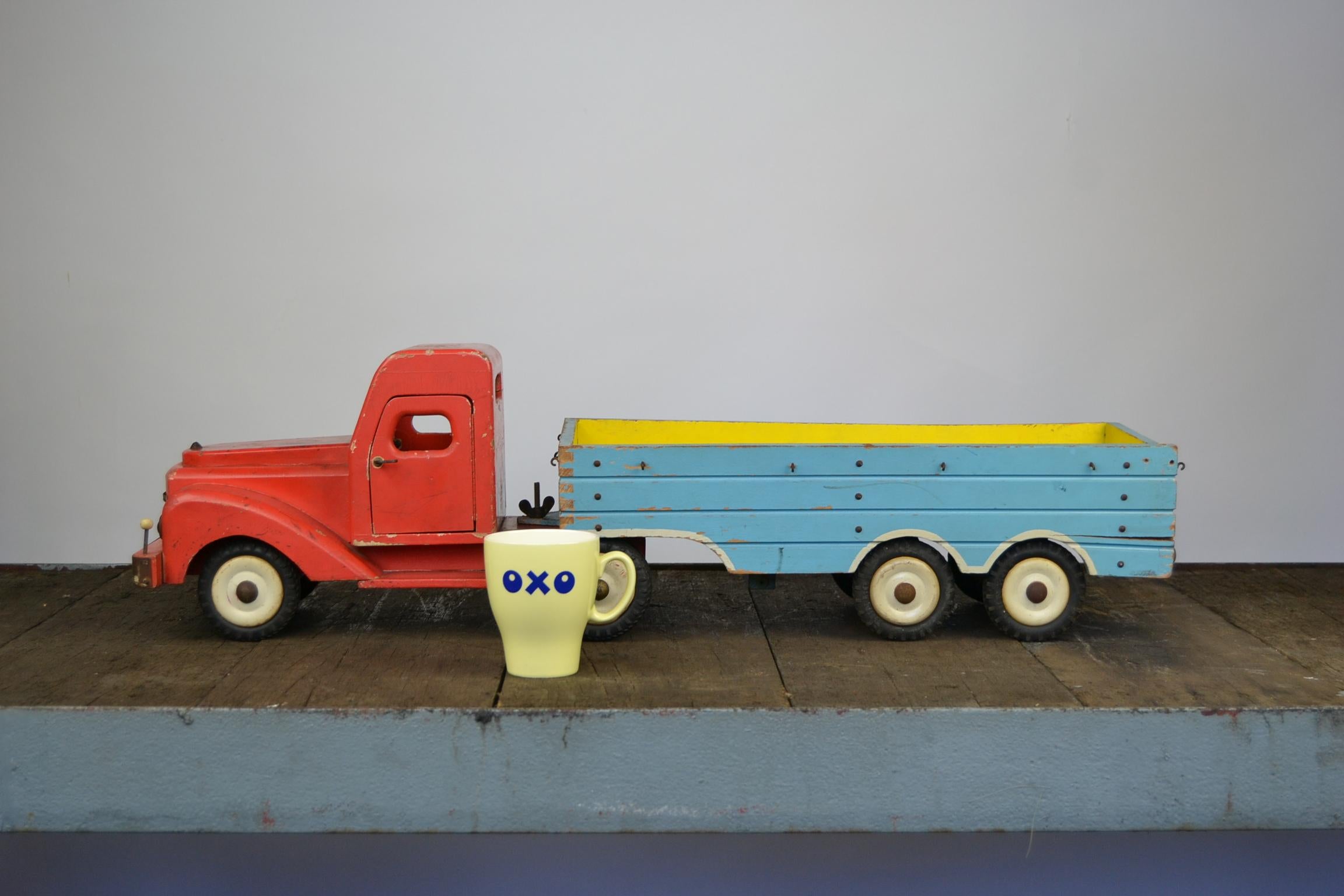Large toy truck with trailer. Total length: 30.51 inch – 77.50 cm !
This 1950s wooden toy truck has the painted colors red, blue and yellow.
The logo of the Toy Company Bigge is still in front and at the back. 
Doors of the truck cabin can be opened