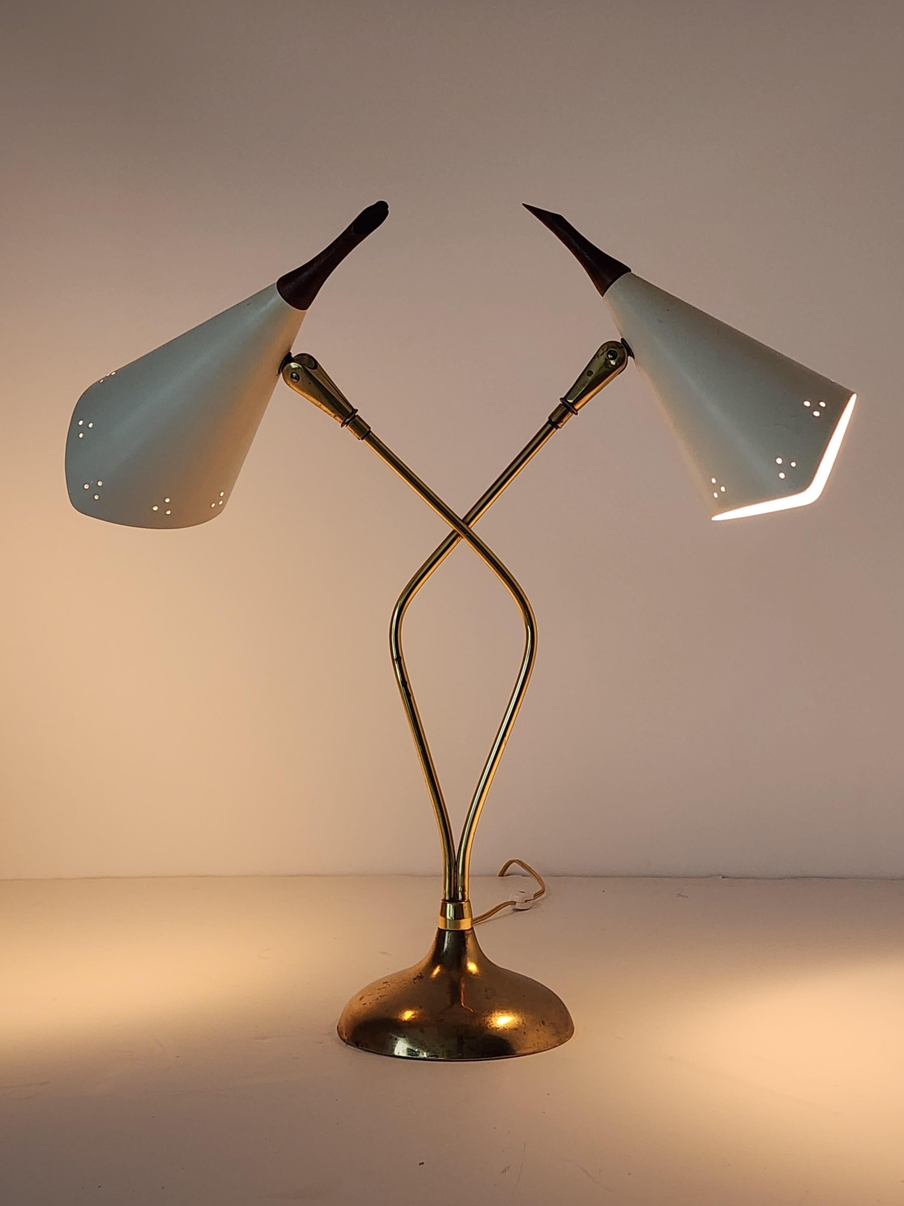 Sensuous shaped table lamp from Laurel Mfg. USA .  1950s

Pierced , enameled shade sitting on a tall  brass structure . 

The walnut tip end serve as an On/Off switch 

Contain 2 E27  Edison  socket  rated at 60 watt . 