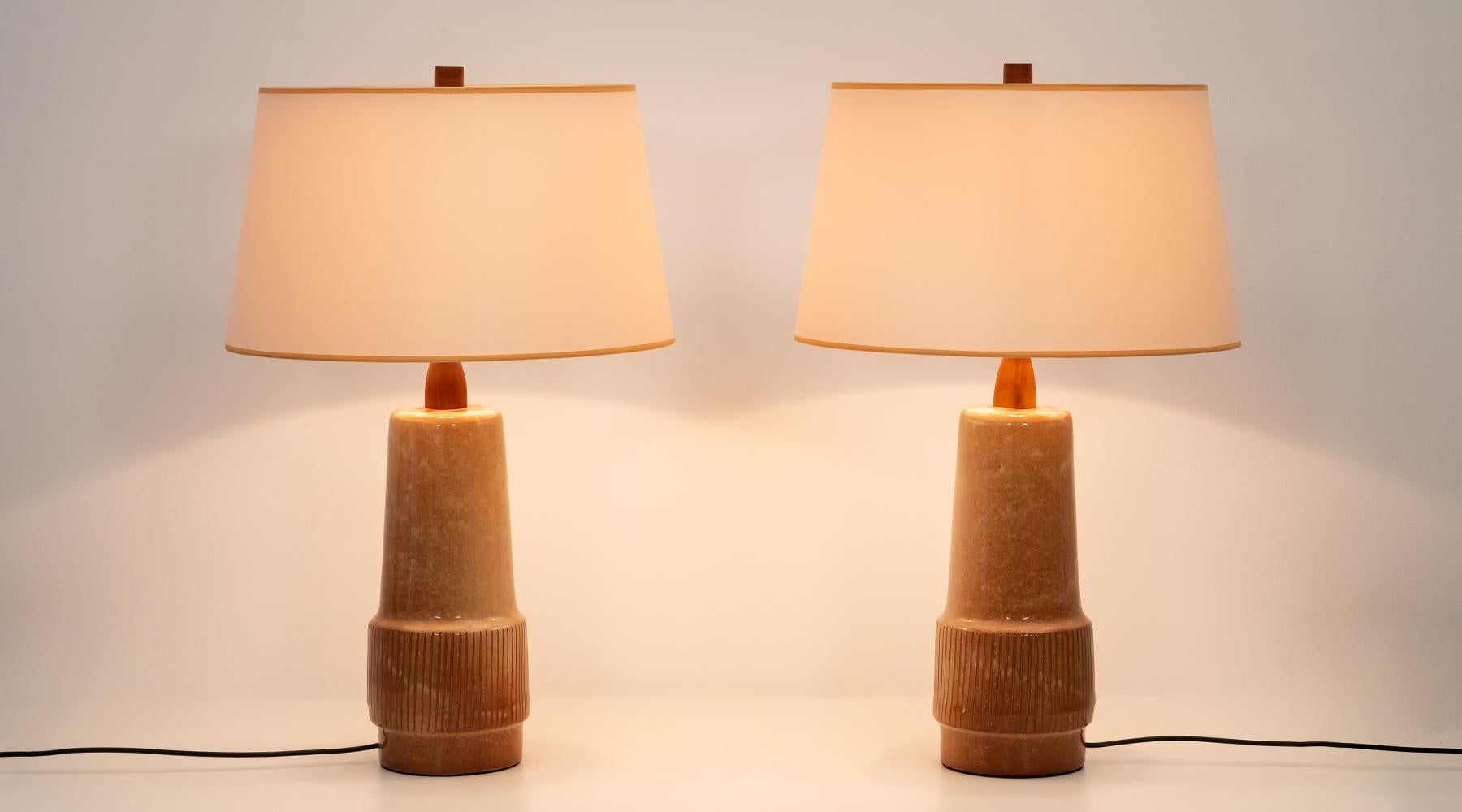 Pair of table lamp, warm, light, brown ceramic, light shadow, Jane and Gordon Martz, USA, 1954

A perfectly matching pair of table lamps in the typical earthy and sandy colours by Gordon & Jane Martz. 
The light shade with matching border follows