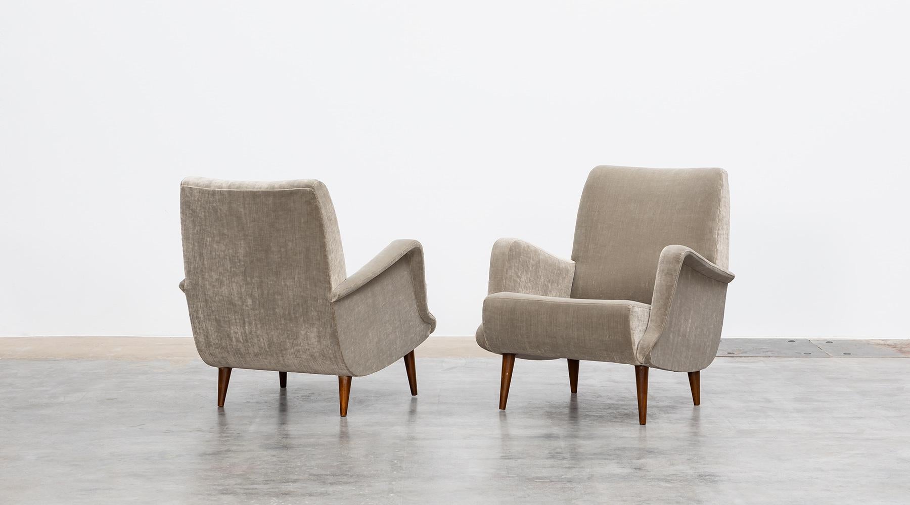 Lounge Chairs by Carlo de Carli, New upholstery in light, warm grey high-quality fabric, Italy, 1954.

A pair of lounge chairs designed by Carlo de Carli. The sensual curves and elegantly tapering legs give the chairs a sculptural, modern look.