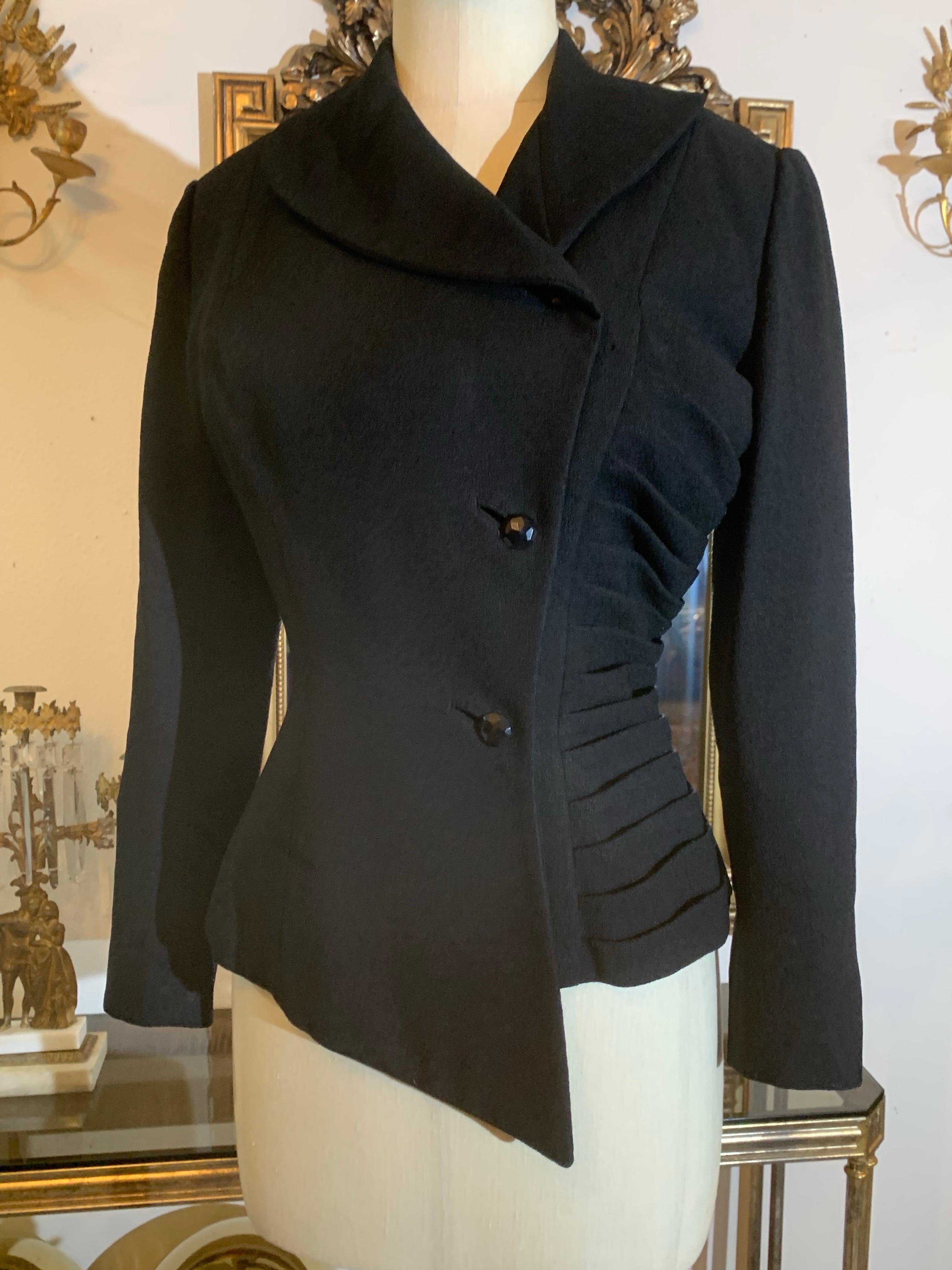 1950 Lilli Ann Giacca da abito asimmetrica aderente in crepe di lana nera con arricciatura laterale: Un meraviglioso esempio dello stile sartoriale tipico di Lilli Ann in un leggero crepe di lana primaverile.  Un lato è plissettato a coltello in