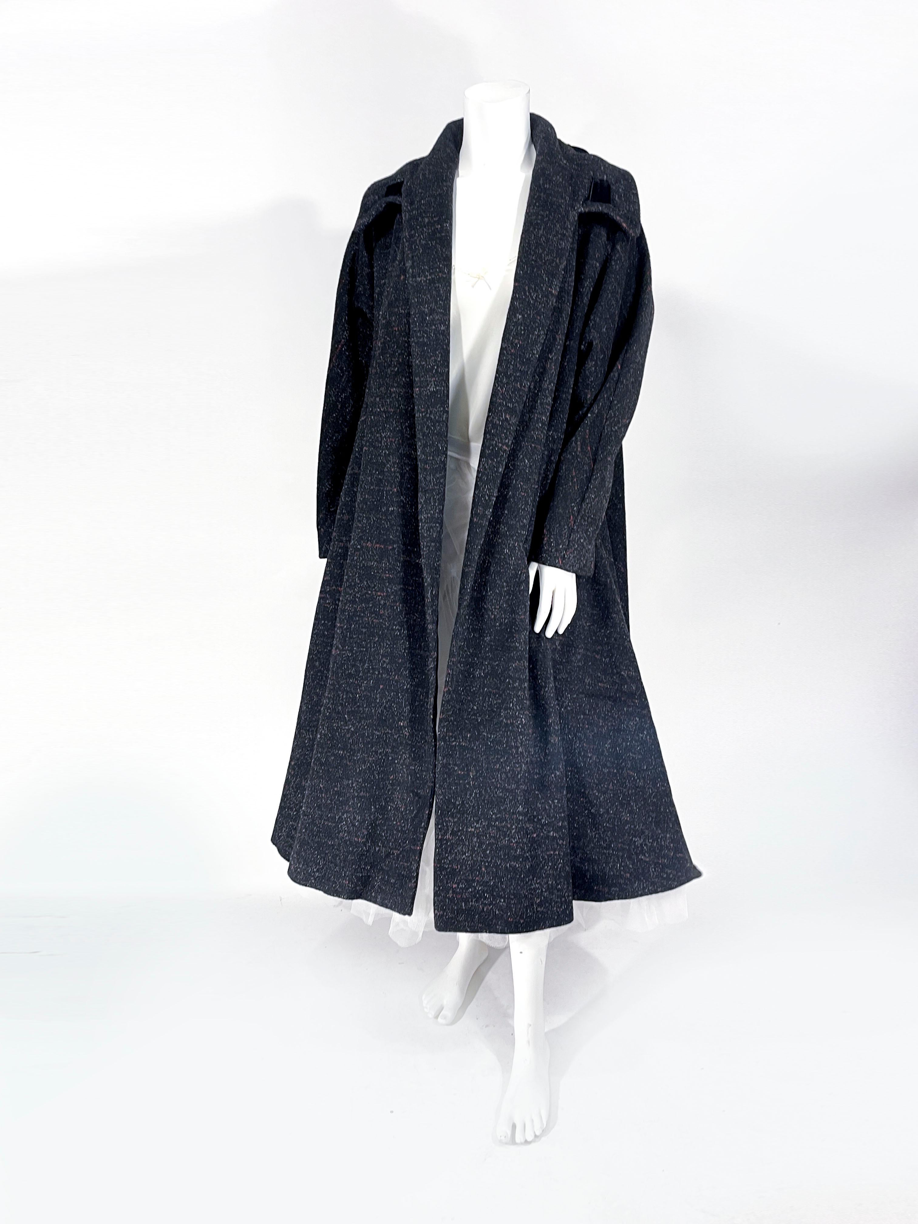1950s Lilli Ann Swing coat featuring a woolen textile with fed horizontal flecked lines and white fleck throughout. The shawl collar warps around to a wide part of the collar decorated with a wide velvet band laced in and out of the edge. The wide
