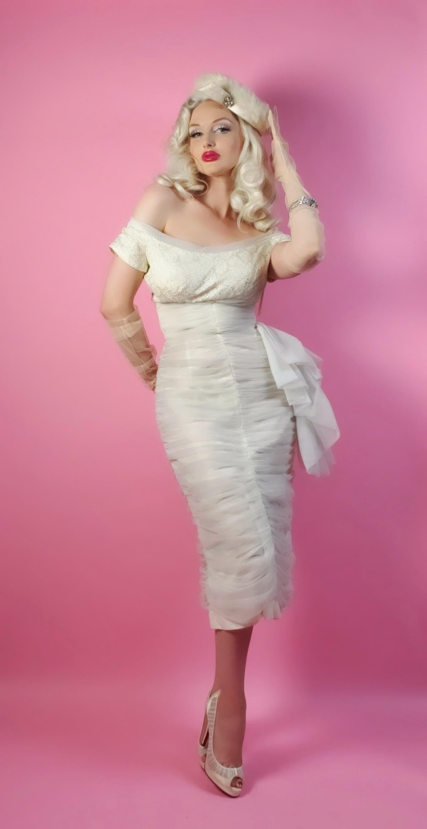 A seductive and highly stylized 1950's white chiffon cocktail dress by the famous Lilli Diamond. The silhouette is classic pin-up 
