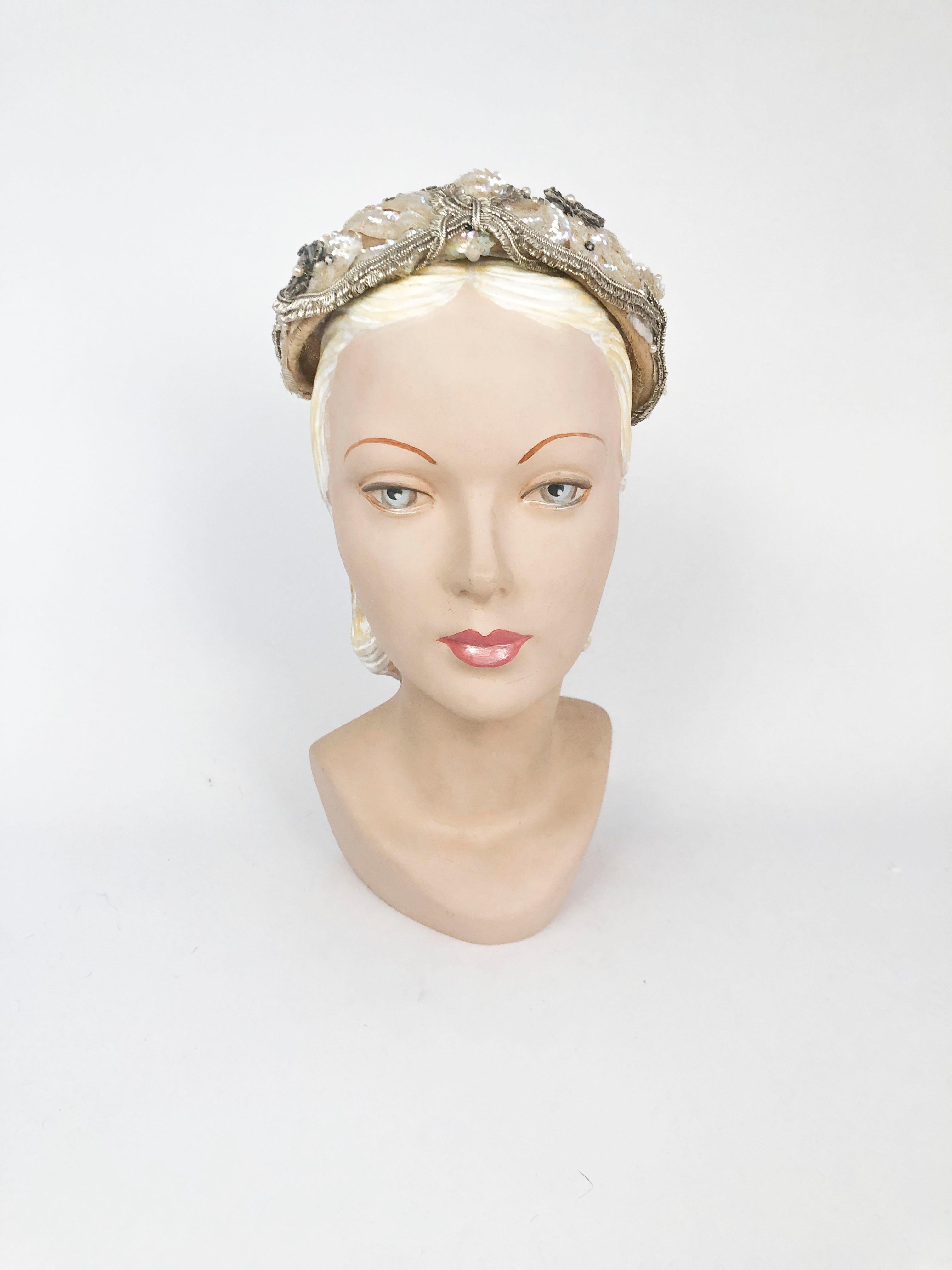 1950's Lilly Dache Hand Decorated Hat in cream with sequin, silk, lamé, and silver rhinestones. The hat is structured with a horsehair body.