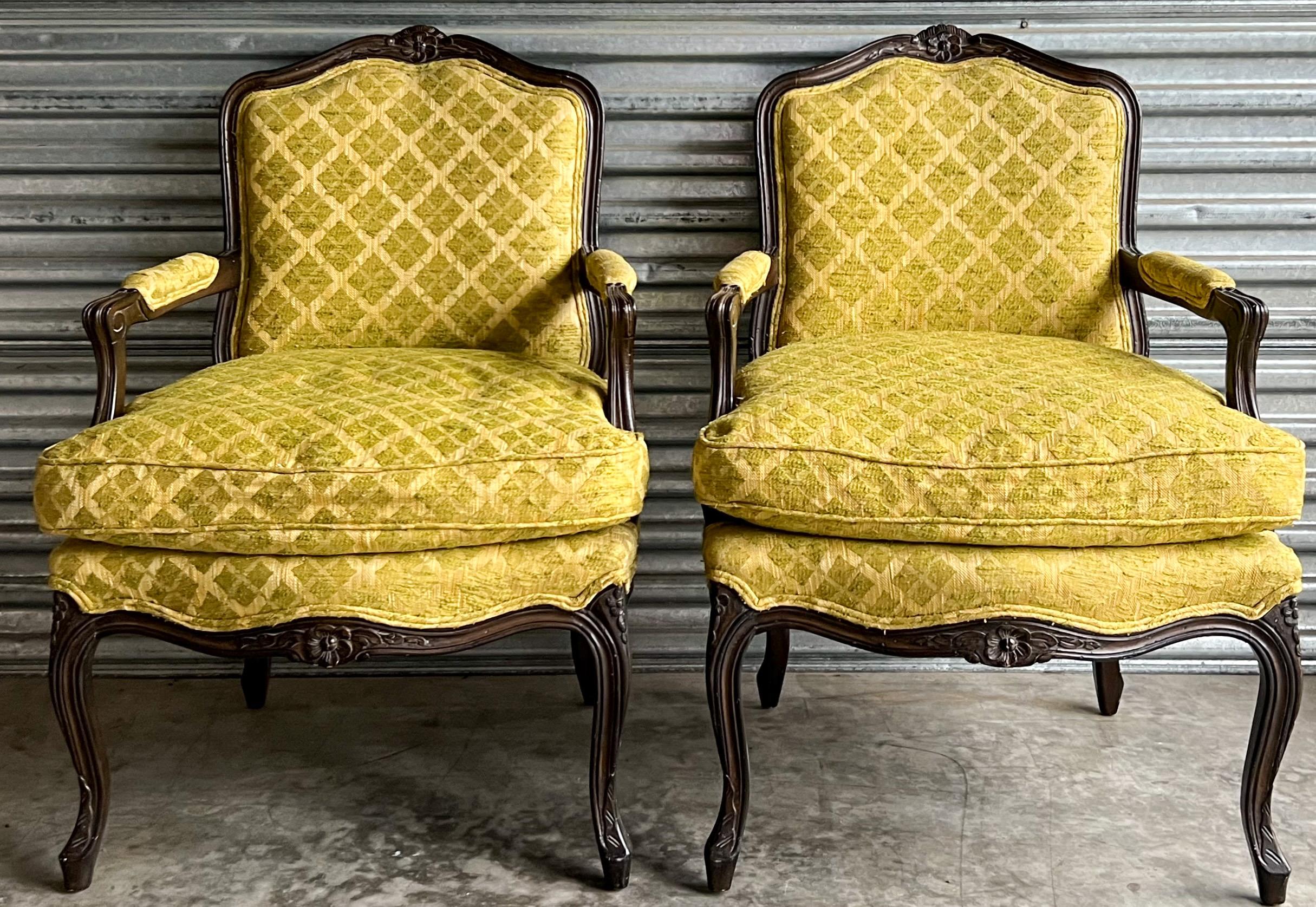 This is a pair of mid-century Louis XV carved and ebonized bergere chairs. The vintage upholstery is in decent condition and is almost chartreuse in color. The cushion is down. They are unmarked.