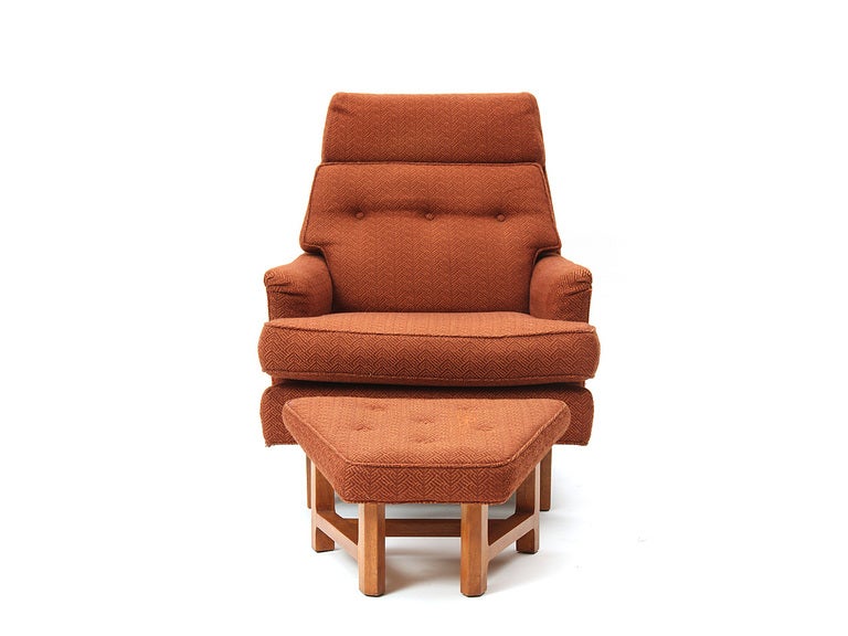 A Mid-Century Modern high-back chair and ottoman set designed by Edward Wormley featuring mahogany bases and original orange upholstery. Made by Dunbar in the USA, circa 1950s.