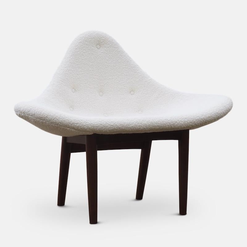 A rare midcentury lounge chair of dramatic sculptural form with contrasting dark brown wood legs.
Upholstered with Deda Karakoum ivory bouclé fabric.