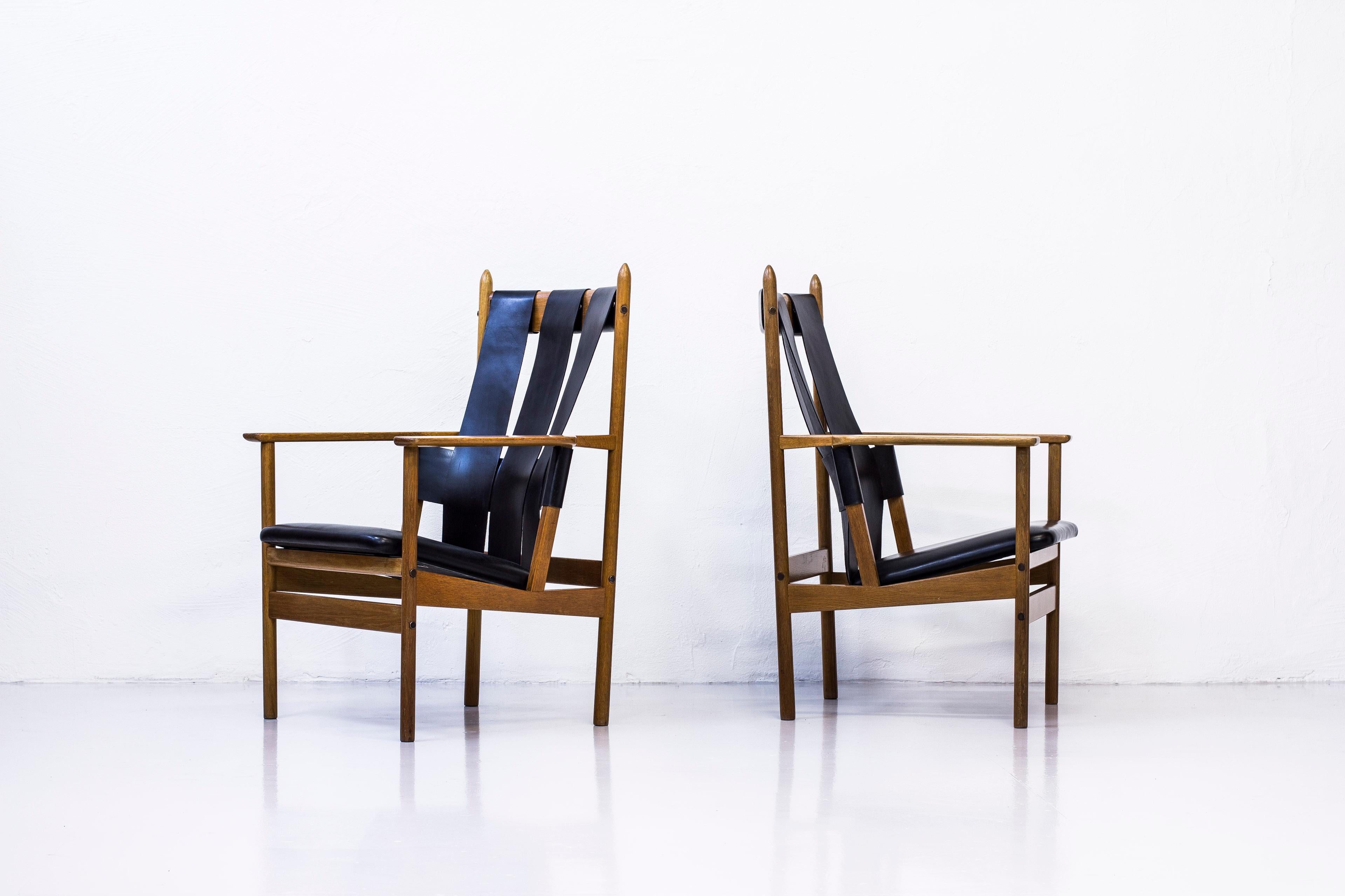 Rare pair of lounge chairs designed by Gunnar Eklöf. Produced in Sweden by Gärsnäs, in the 1950s. Made from solid oak with brass details and thick original hide and leather. Excellent condition with light wear and patina.