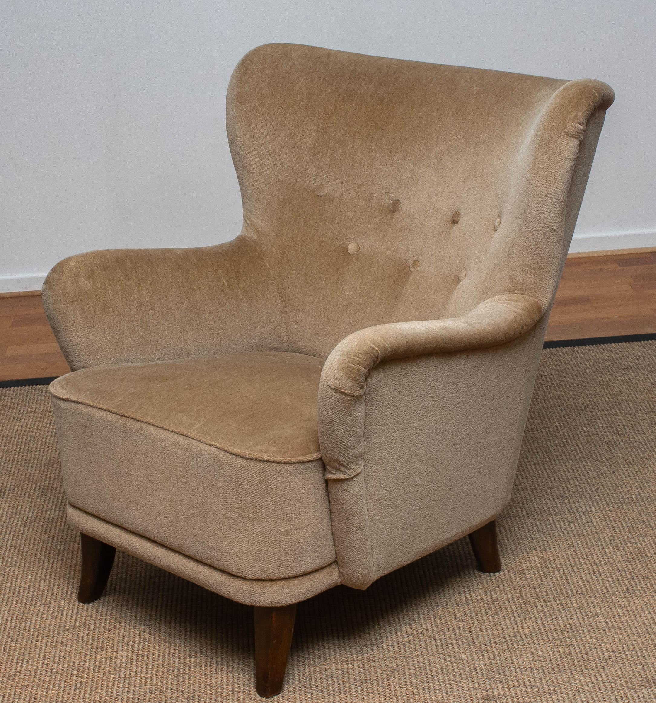 1950s lounge / club chair designed by Ilmari Lappalainen for Asko in Finland.
The chair is upholstered with beige velvet.
This chair has some wear spots due to use.


  