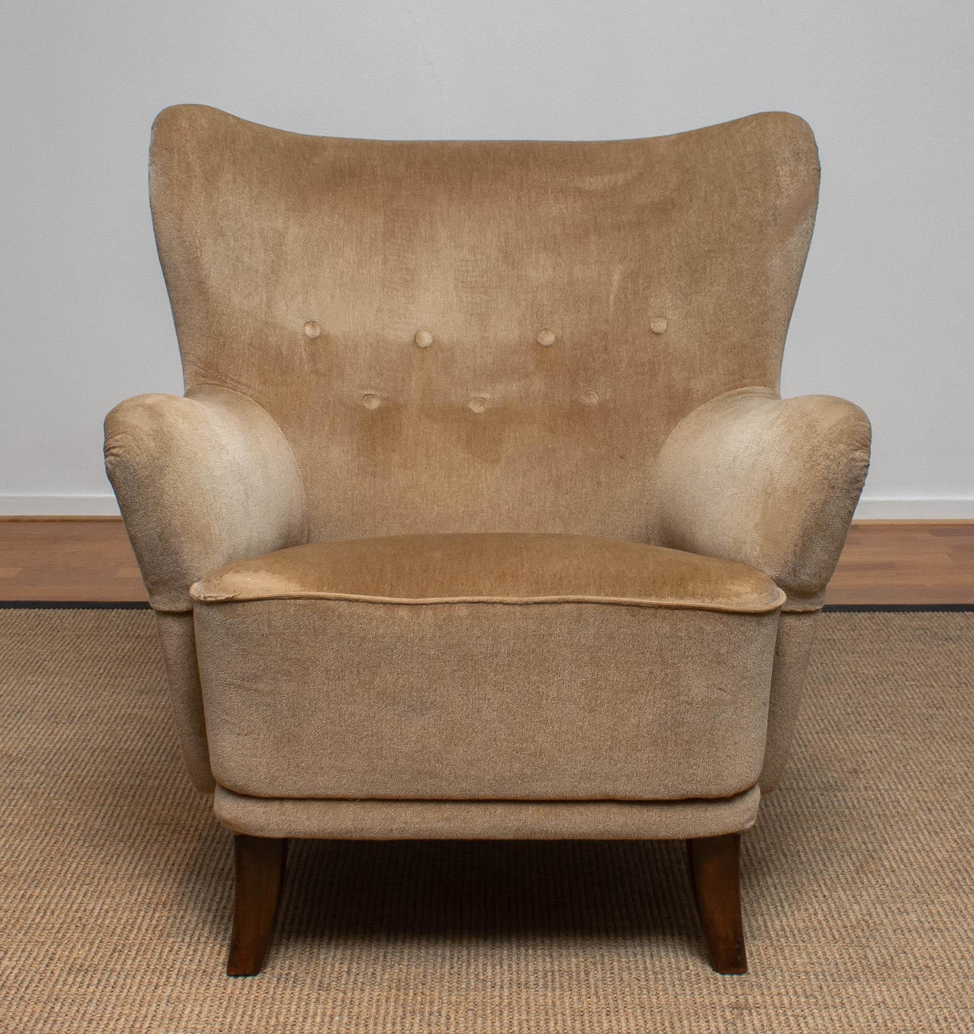 1950s lounge or club chair designed by Ilmari Lappalainen for Asko in Finland.
The chair is upholstered with beige velvet.
This chair has some wear spots due to use
  
  