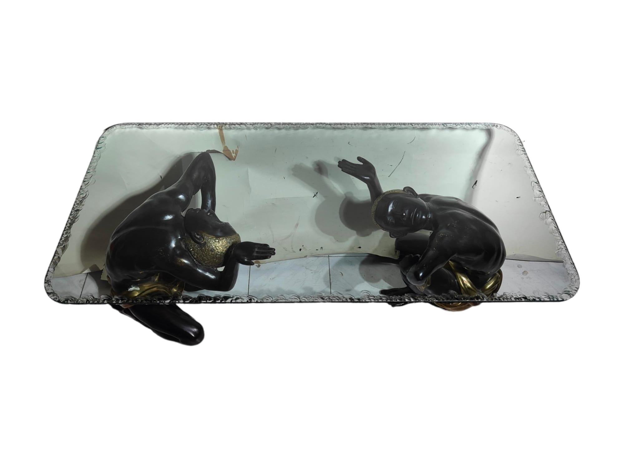 Relive the timeless elegance of the 1950s with this refined low table, featuring two bronze figures gracefully supporting the glass top. In excellent condition, this table with dimensions of 140x70x50 cm is not only a testament to the classic