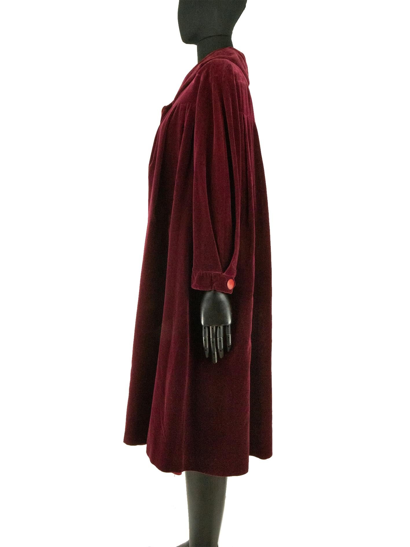 A burgundy red velvet cloak from Parisian couturier Lucile Manguin, daughter of impressionist painter Henry Manguin. The cloak is floor length and features softly pleated folded into the back and front yoke. The sleeves are pleated into the cuff,