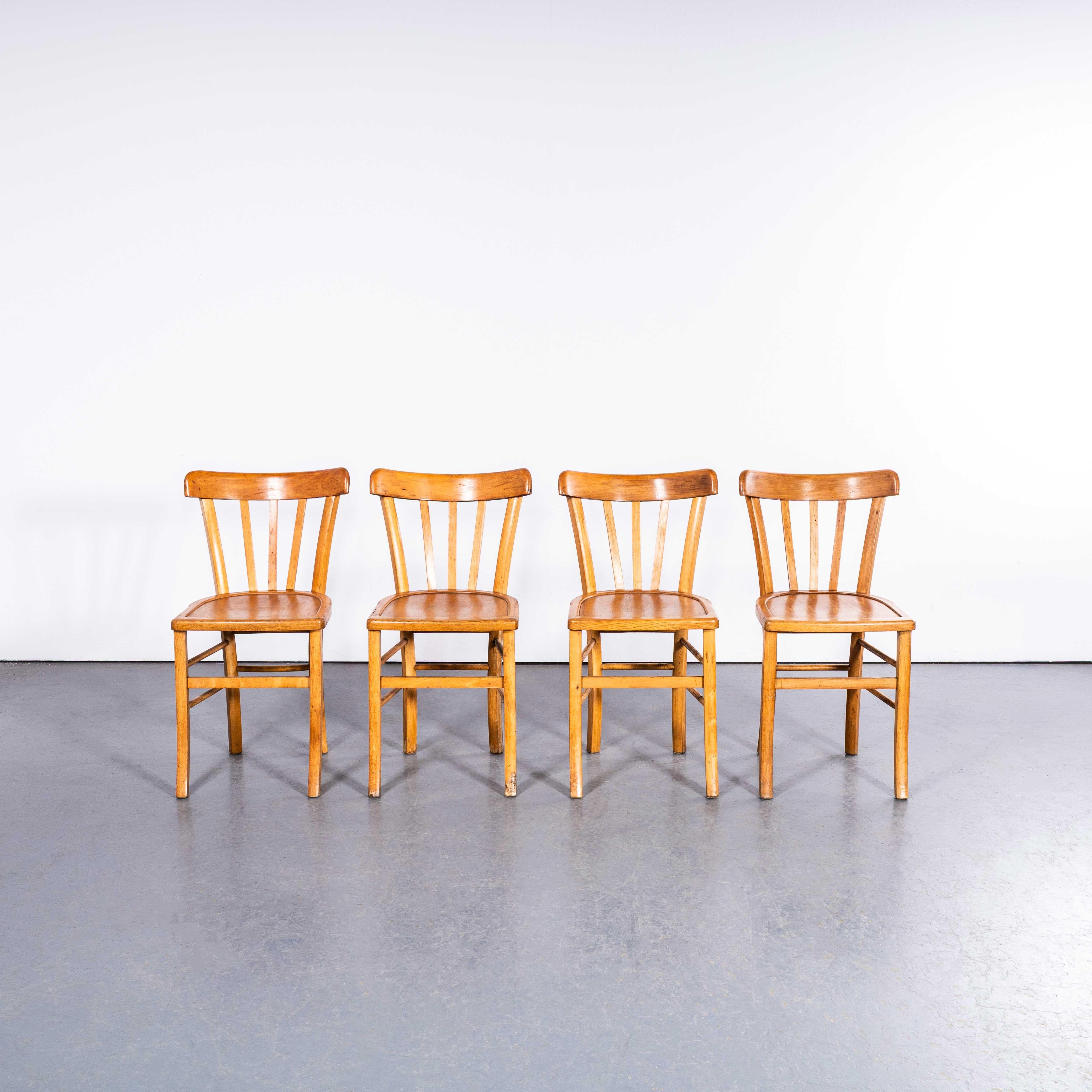 1950’s Luterma Blonde Farmhouse Dining Chairs With Grill Backs – Set Of Four. 

The process of steam bending beech to create elegant chairs was discovered and developed by Thonet, but when its patents expired in 1869 many companies including Luterma