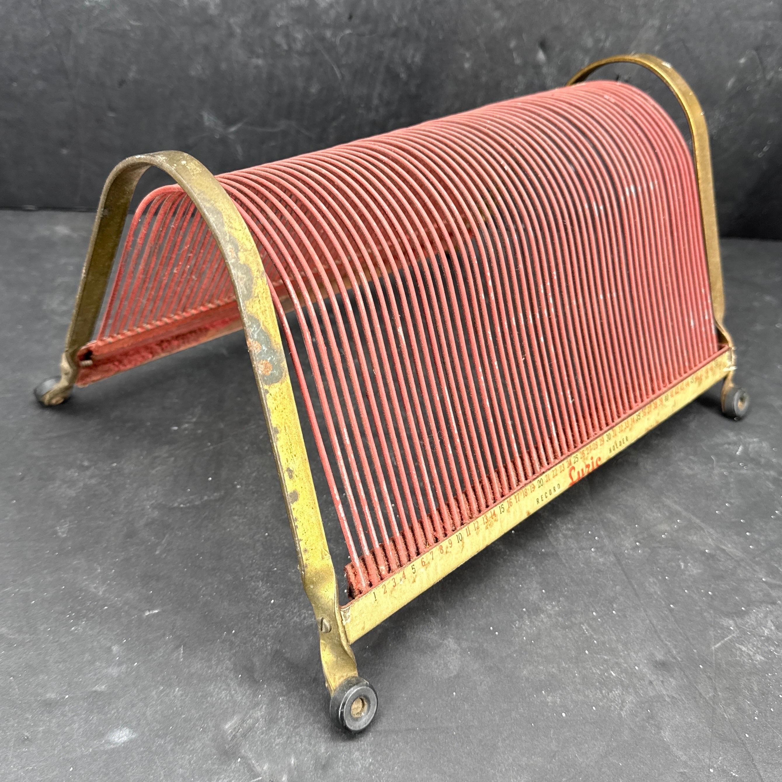 Vintage record holder for any music lover. The Lyric wire rack has a Mid-Century retro design that adds a touch of nostalgia to any room. The holder is painted in red with brass surround. It’s antique appearance and quality craftsmanship make it a