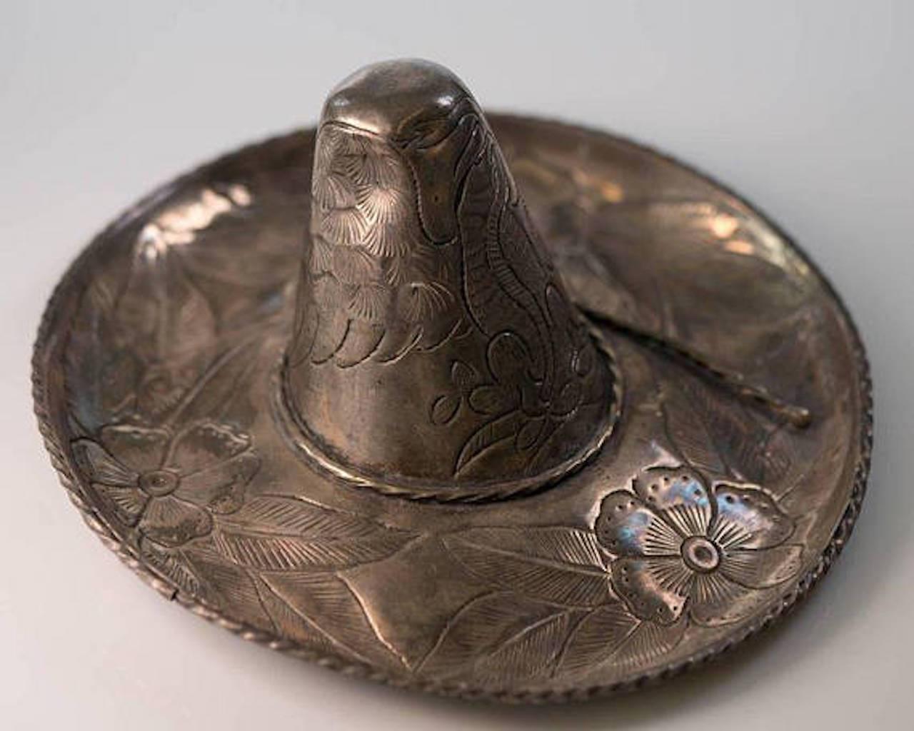 This 1950s Retro Hand Engraved Sterling Silver Sombrero Sculpture makes a Great Conversation piece! 

Mexican artist Maciel created this unique piece from .925 sterling silver. The upper and undersides of the sombrero are engraved with a floral