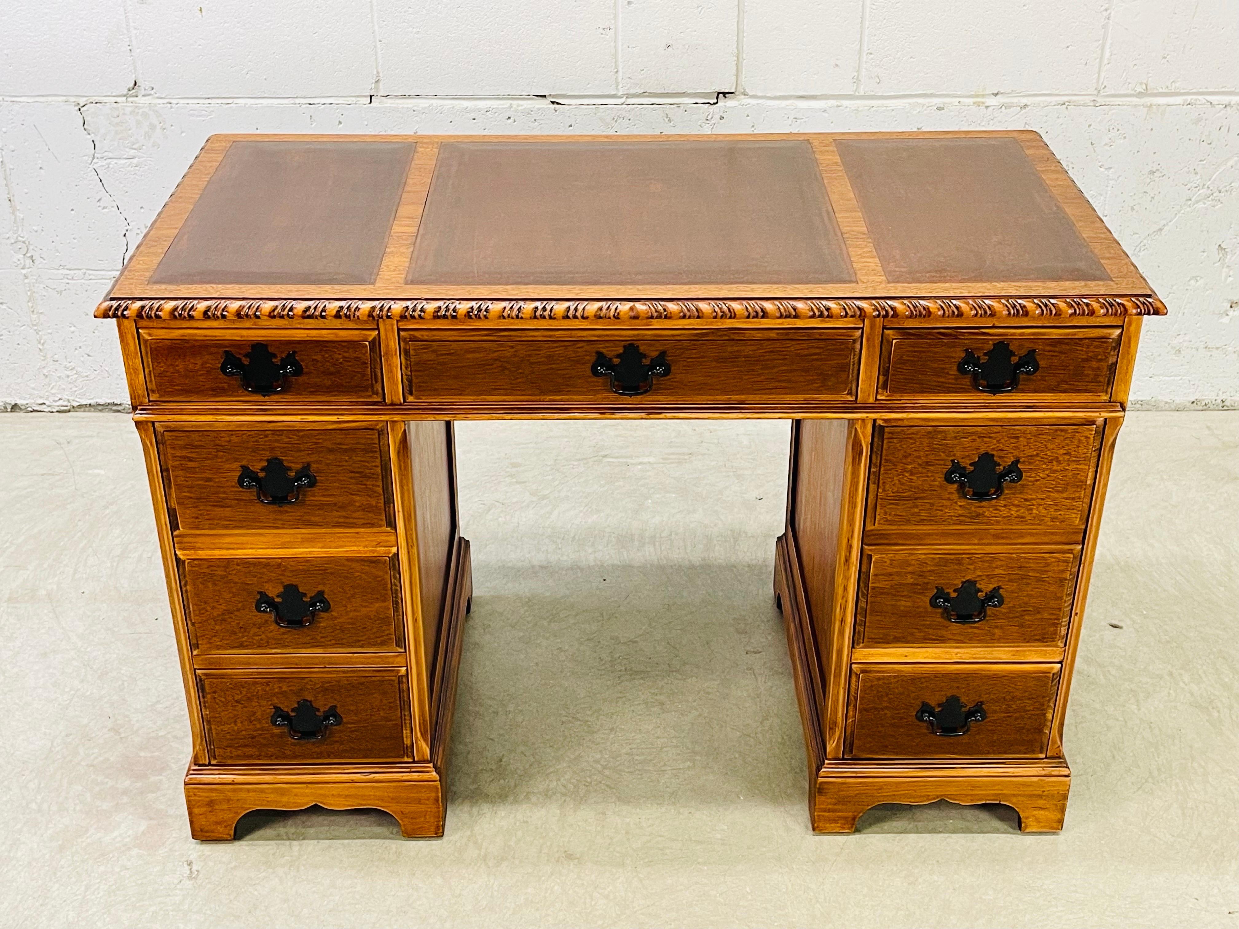 Vintage 1950s mahogany wood and leather top desk. The desk has seven drawers for storage. The knee clearance is 24”H. All the drawers are dovetailed. Leather is in excellent condition. No marks.
