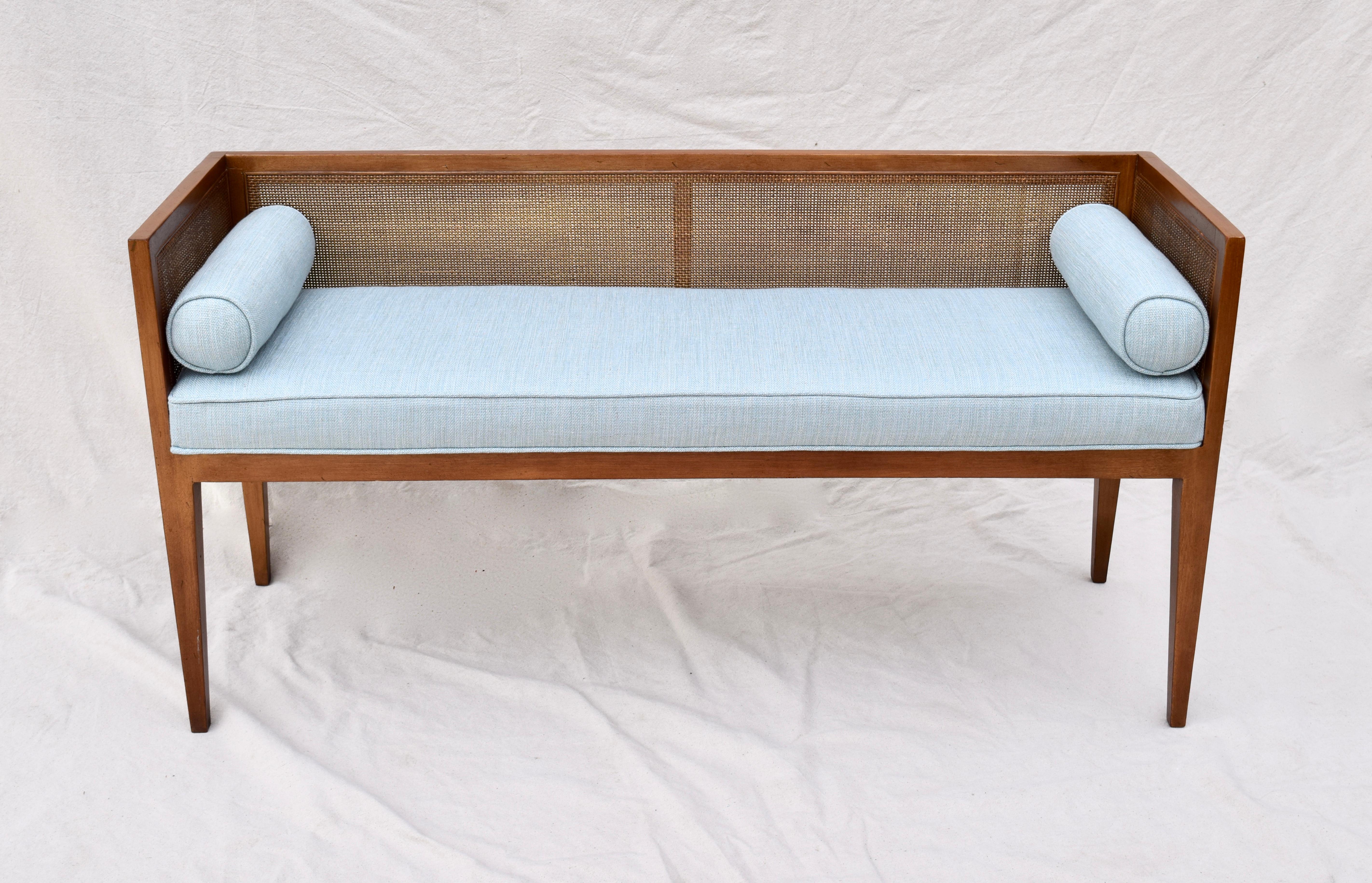 Solid mahogany Mid-Century Modern window bench or settee attributed to Edward Wormley for Dunbar. Lithe line design constructed of mahogany frame with original fine scale caning. Restored seat and bolster cushions are upholstered is soft blue linen.